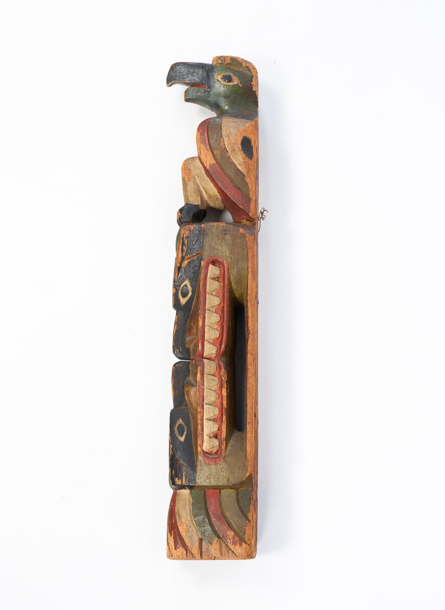 DIMINUTIVE NATIVE AMERICAN PACIFIC NORTHWEST TOTEM.: DIMINUTIVE NATIVE AMERICAN PACIFIC NORTHWEST TOTEM. Early 20th Century. Carved and paint-decorated. A bird seated atop two opposing large tooth figures in red, green, and black paint. 18"h.