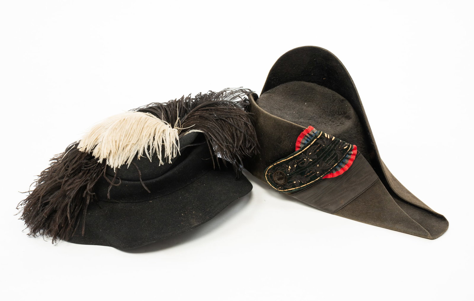 TWO FRENCH HATS.: TWO FRENCH HATS. French, 19th-20th Century. A black felt military bicorne hat with embroidered adornment, the inside label reading "Manufacture De Paris." A black felt hat with black and white plumes,