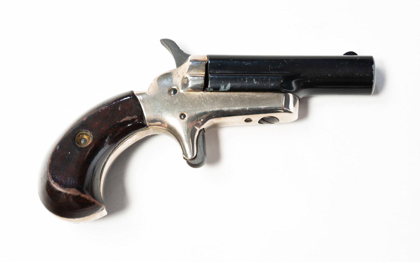 COLT DERRINGER MODEL 4 .22 SHORT IN PRESENTATION BOX.: COLT DERRINGER MODEL 4 .22 SHORT IN PRESENTATION BOX. American, Mid-20th Century. Serial 83121D. 2 1/2" side-pivoting blue barrel, varnished walnut grips, nickel frame. With some original paperwork an