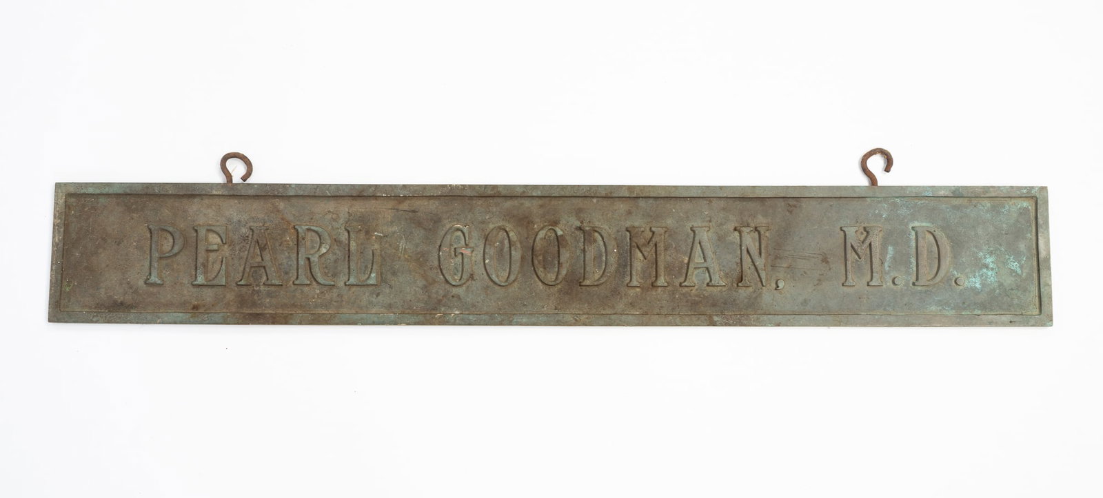 "PEARL GOODMAN, M.D." BRONZE DOCTOR'S OFFICE SIGN.: "PEARL GOODMAN, M.D." BRONZE DOCTOR'S OFFICE SIGN. American, Early-mid 20th Century. Long, rectangular bronze hanging sign with verdigris surface, reading "Pearl Goodman, M.D." 6.25"h. 34.5"w.