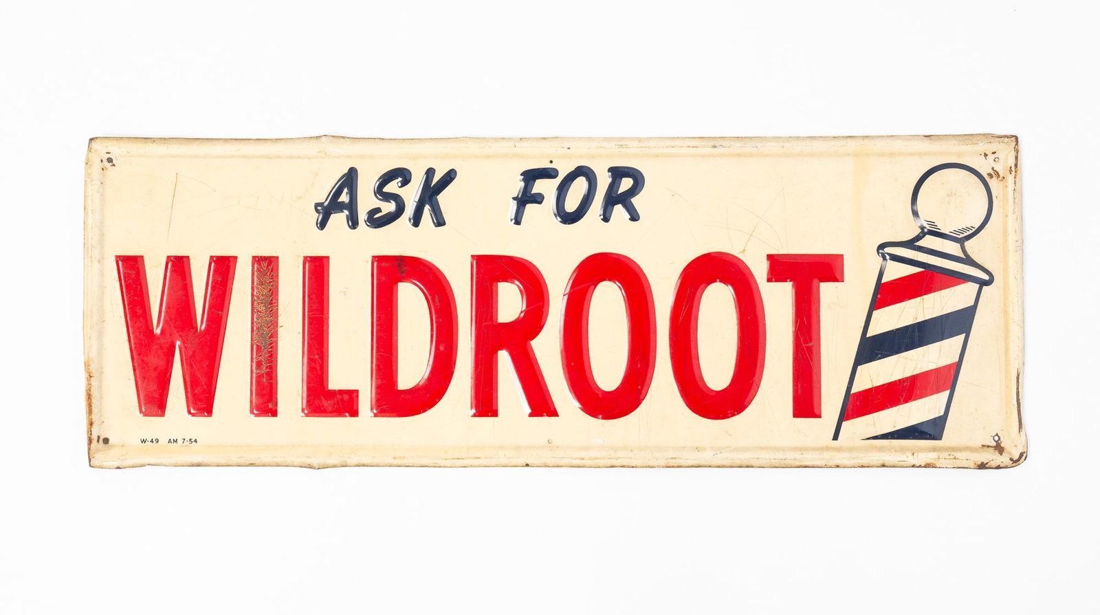 AMERICAN "ASK FOR WILDROOT" BARBERSHOP ADVERTISING TIN SIGN.: AMERICAN "ASK FOR WILDROOT" BARBERSHOP ADVERTISING TIN SIGN. 20th Century. Die-pressed with white, red, and blue paint. Marked "W-4 AM 7-54" lower left. 9.75"l. 27.5"w. Provenance: From the late
