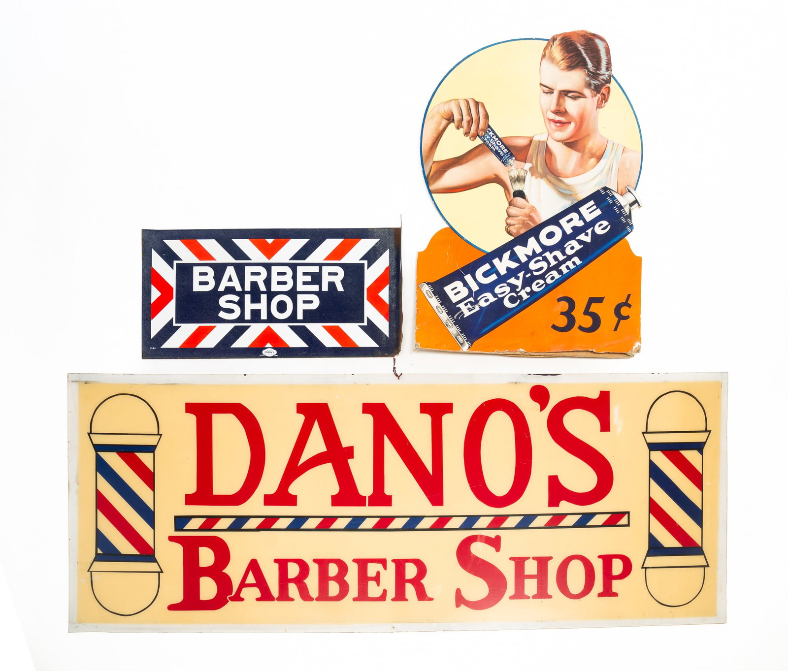 TWO BARBER SHOP SIGNS AND A SHAVE CREAM SIGN.: TWO BARBER SHOP SIGNS AND A SHAVE CREAM SIGN. American, 20th Century. Porcelain enameled and flanged wall sign reading "Barber Shop" on a background of red, white, and blue chevrons, made by William