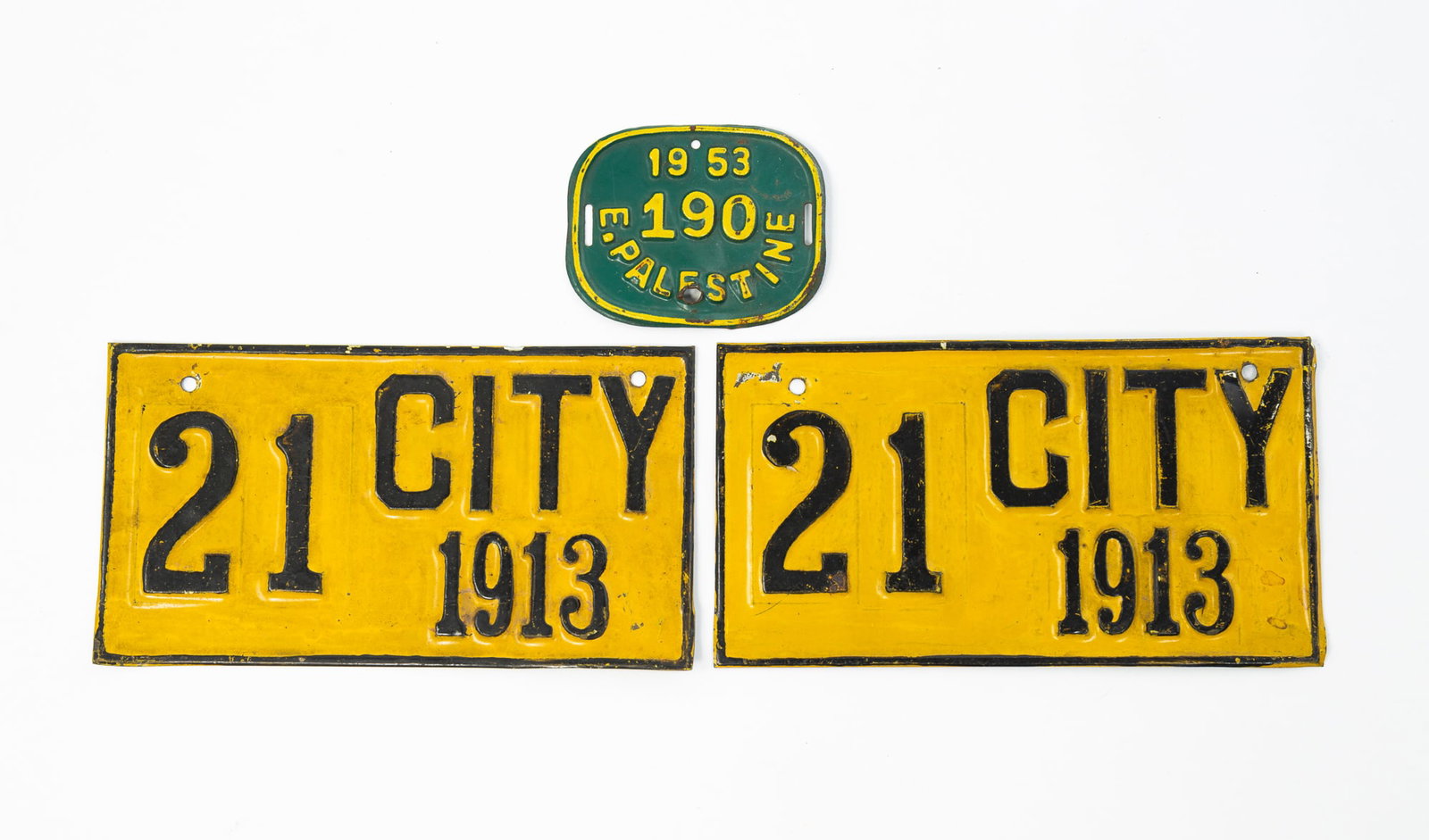 THREE SMALL LICENSE PLATES, POSSIBLY FOR MOTORCYCLES.: THREE SMALL LICENSE PLATES, POSSIBLY FOR MOTORCYCLES. American, 20th Century. There are die-stamped tin. Two are yellow with black trim, lettered "CITY 1913". 3.25"h. 6"w., and the third is rectangula