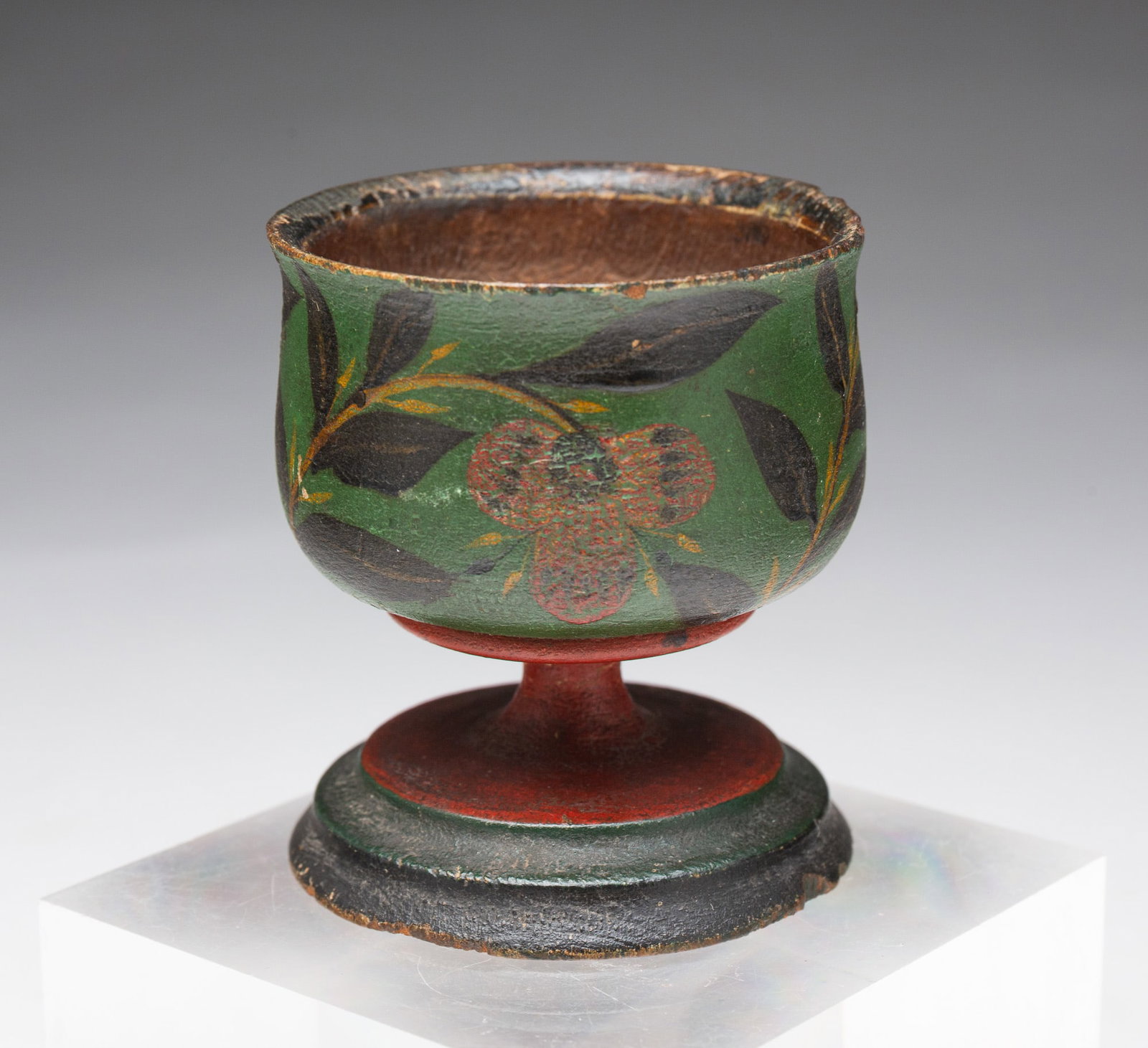 UNUSUAL PENNSYLVANIA LEHNWARE TURNED PINE EGG CUP WITH GREEN PAINT.: UNUSUAL PENNSYLVANIA LEHNWARE TURNED PINE EGG CUP WITH GREEN PAINT. American, 19th Century. Bulbous body, short stem, and round, stepped foot. Original green, red, and black paint with vining floral d