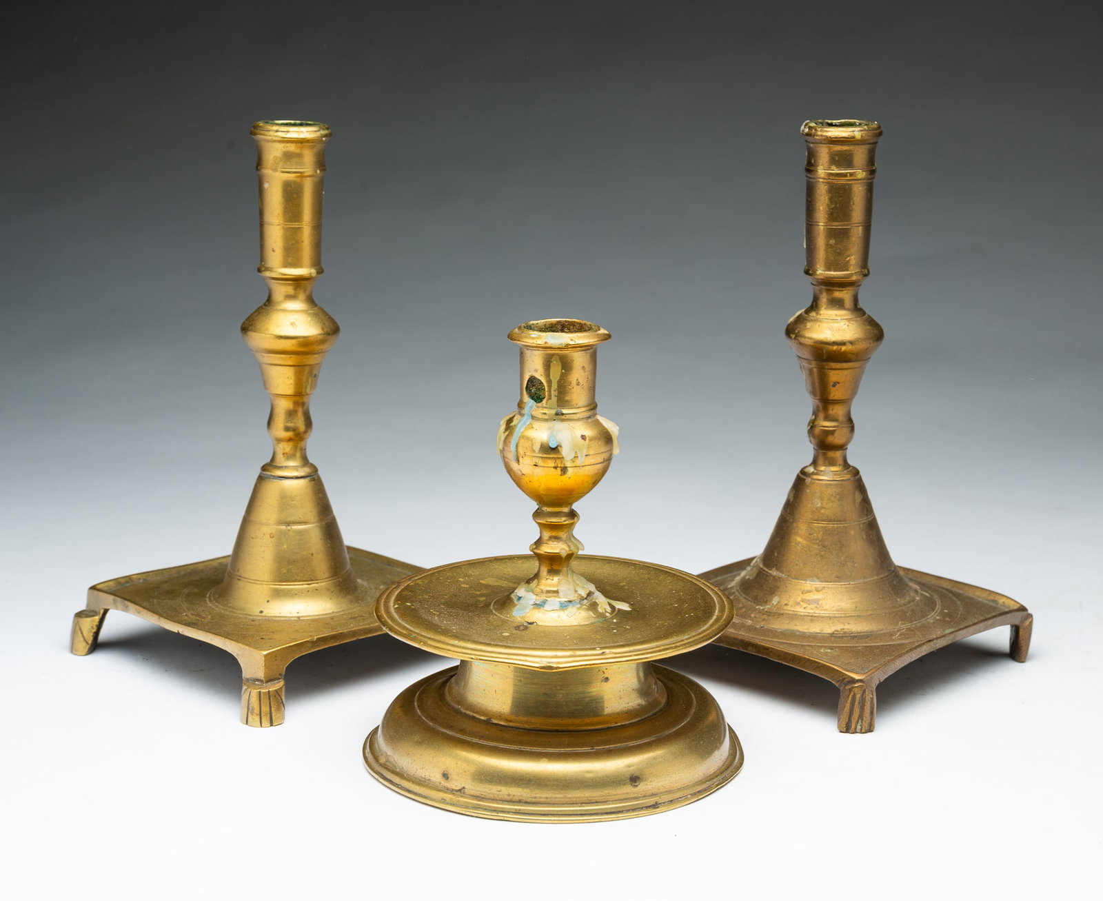 THREE EUROPEAN BRASS CANDLESTICKS. (1 of 4)