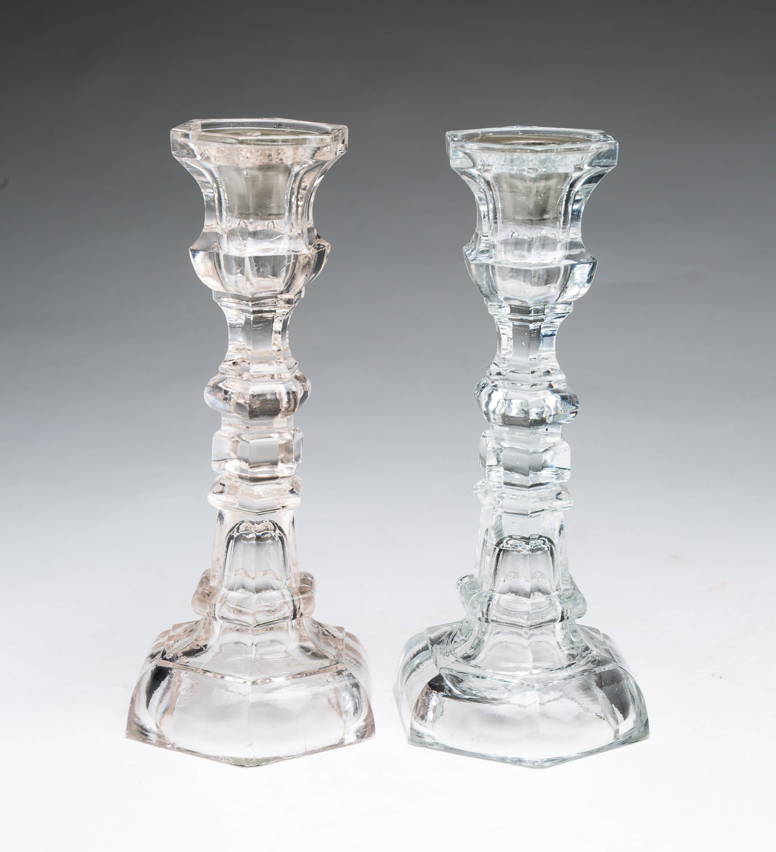 PAIR OF FLINT GLASS CANDLESTICKS WITH PEWTER INSERTS.: PAIR OF FLINT GLASS CANDLESTICKS WITH PEWTER INSERTS. American (likely Pittsburgh), 19th Century. Hexagonal-shaped stems, round feet, and pewter candle cup inserts. 9.5"h. Provenance: From the