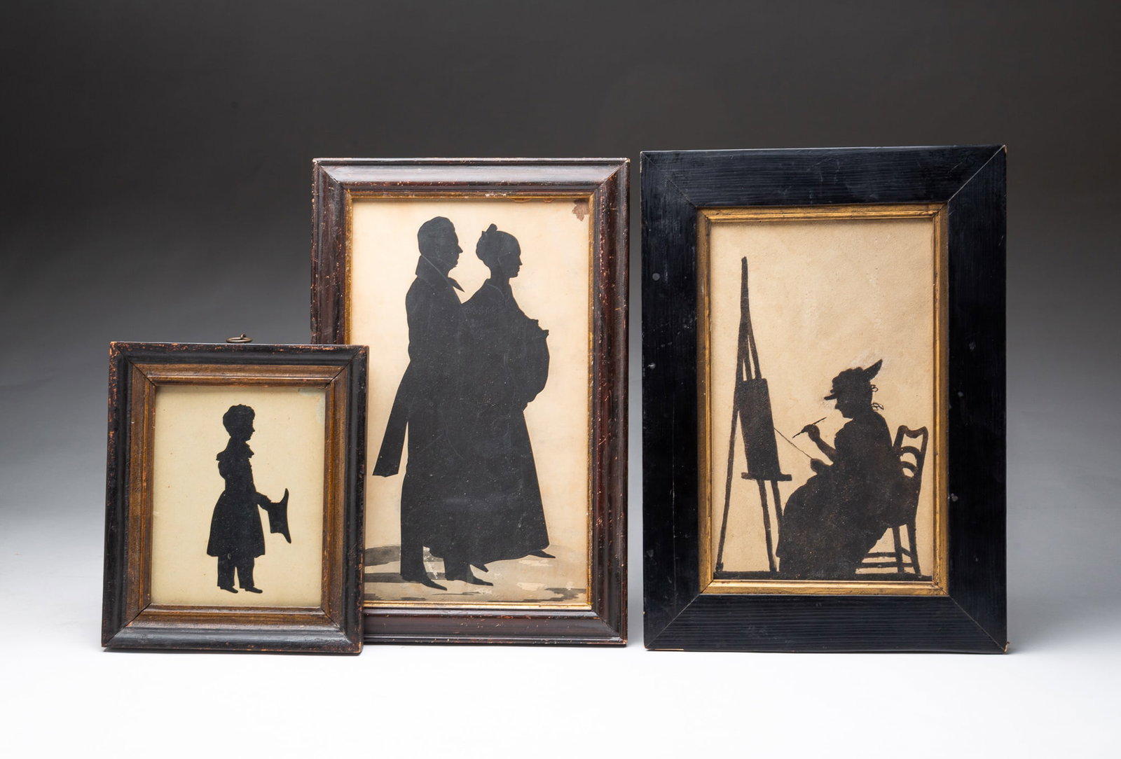 THREE MINIATURE FULL-LENGTH SILHOUETTE PORTRAITS.: THREE MINIATURE FULL-LENGTH SILHOUETTE PORTRAITS. American, 19th Century. The first a cut-paper silhouette of a couple in formal attire, embellished with white gouache and ink wash at their feet, in