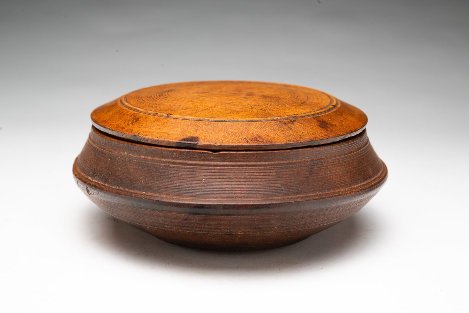 EARLY TREENWARE LIDDED BOWL.: EARLY TREENWARE LIDDED BOWL. American, late 18th or early 19th Century. Turned maple with incised banding. Nice color and patina. 2.75"h. 7.5"d.
