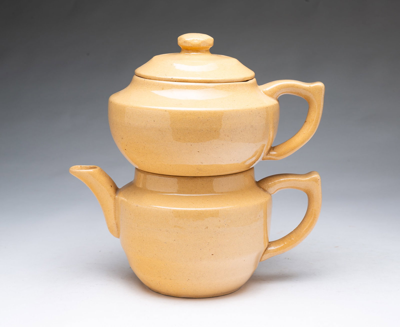 YELLOWWARE NESTING TEAPOT WITH BASKET AND STRAINER.: YELLOWWARE NESTING TEAPOT WITH BASKET AND STRAINER. American, 19th Century. Double-bodied nesting teapot, the top having a lid, handle, and tea basket with lid; the bottom having a spout and handle,