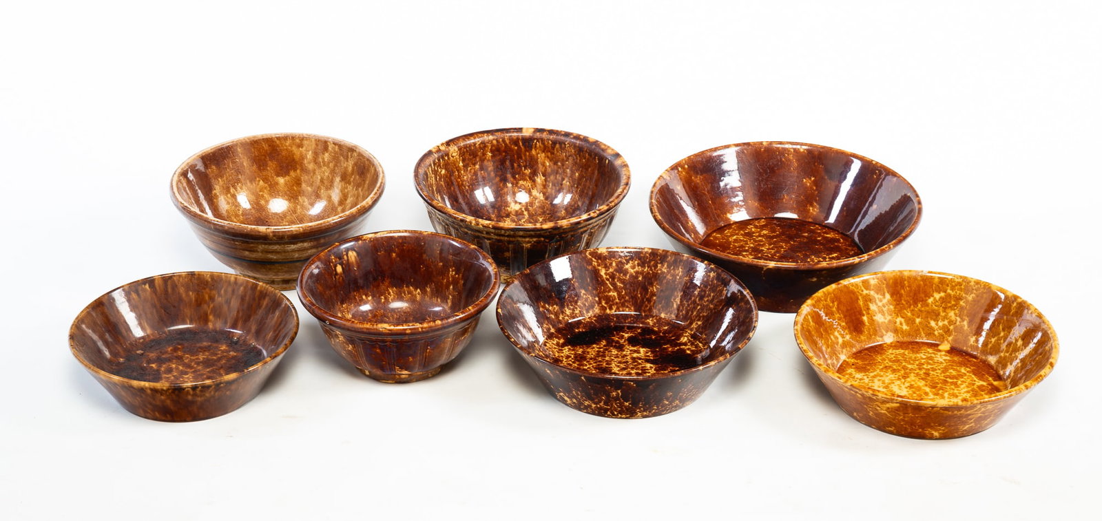 SEVEN ROCKINGHAM BOWLS.: SEVEN ROCKINGHAM BOWLS. American, 19th Century. Includes four bowls with canted sides and three bowls with rounded forms and paneled sides. From 4.5"h. 13"d. to 5"h. 9"d. Provenance: From the
