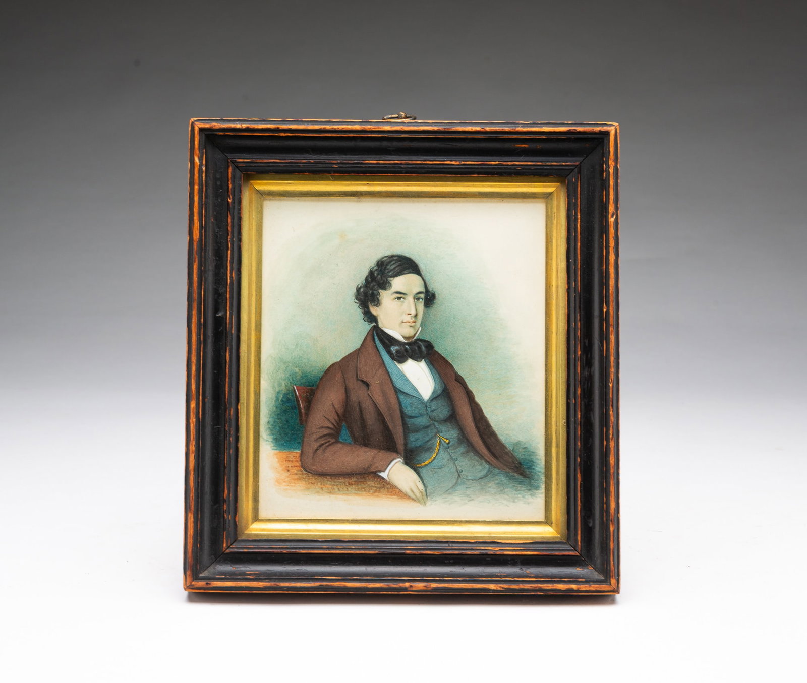 WATERCOLOR PORTRAIT OF A GENTLEMAN.: WATERCOLOR PORTRAIT OF A GENTLEMAN. American, 19th Century. Watercolor on paper. A seated man wearing a high-collar white shirt, a large black necktie, a blue vest with his pocket watch chain showing,