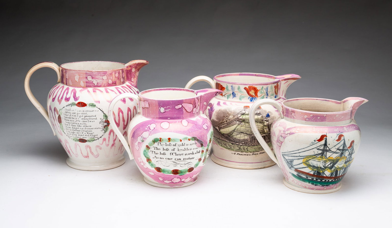 FOUR SUNDERLAND LUSTER PITCHERS.: FOUR SUNDERLAND LUSTER PITCHERS. England, 19th Century. Pitchers with three or two hand-colored transfers, featuring ship scenes and verses with pink decoration. From 8"h. to 6"h.
