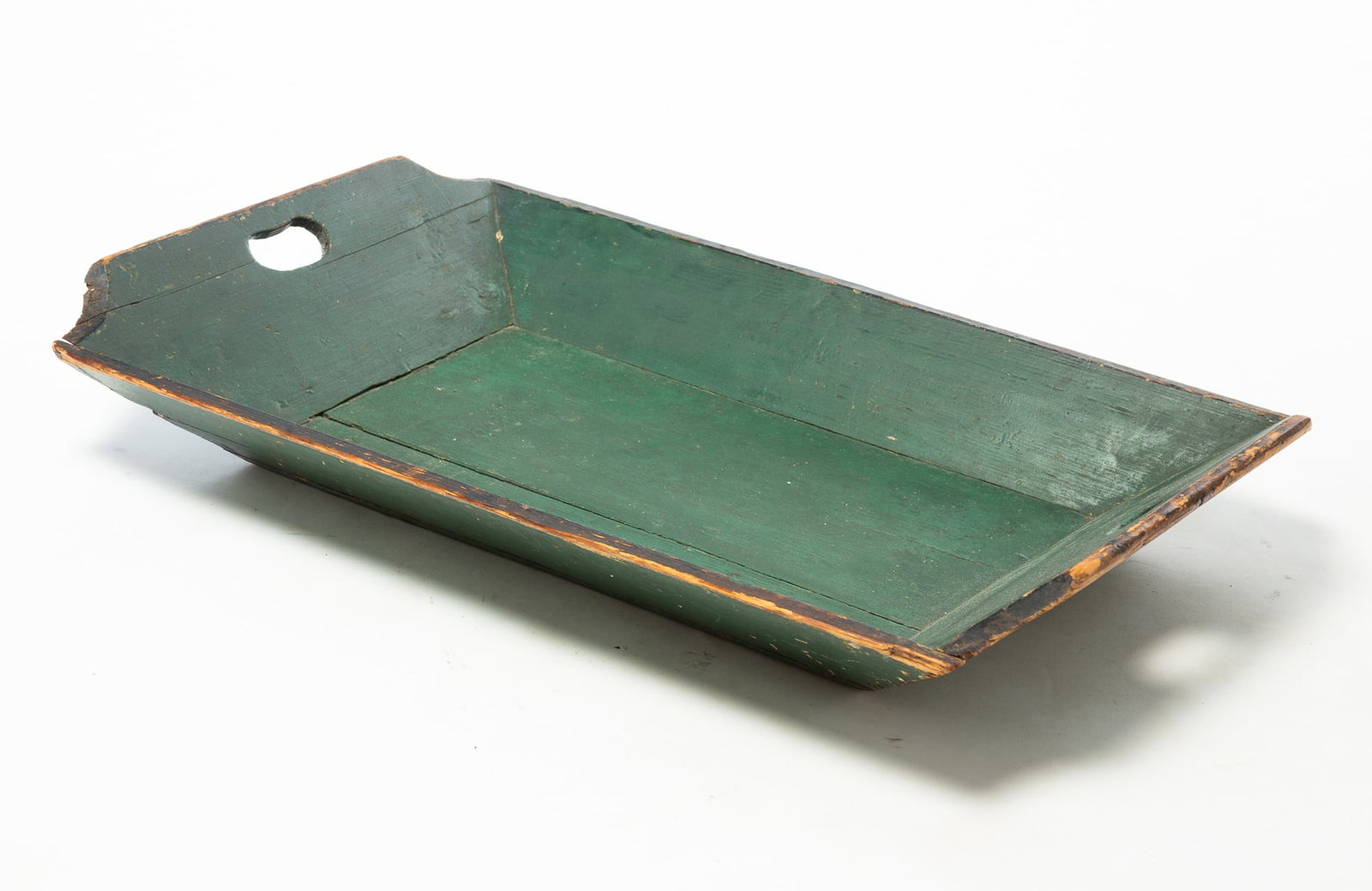 WOODEN APPLE TRAY IN ORIGINAL GREEN PAINT.: WOODEN APPLE TRAY IN ORIGINAL GREEN PAINT. American, 19th Century. Pine. Canted sides, cutout handles on ends, in green paint with black-painted edges. 4.5"h. 28"w. 17.75"d.