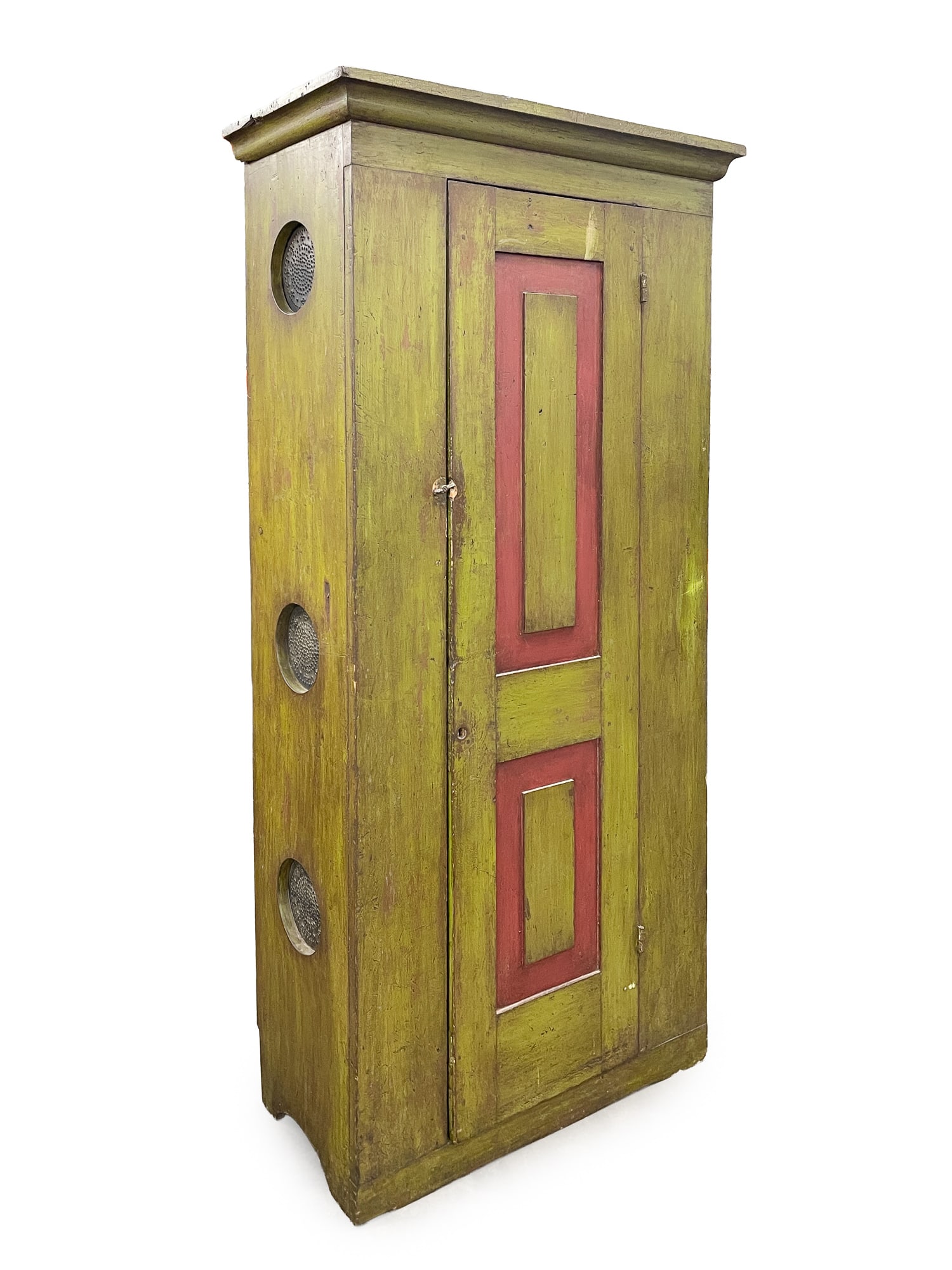 GREEN-PAINTED AND RED-TRIMMED SINGLE-DOOR CUPBOARD WITH PUNCHED TIN SIDE PANELS.: GREEN-PAINTED AND RED-TRIMMED SINGLE-DOOR CUPBOARD WITH PUNCHED TIN SIDE PANELS. American, 19th Century. Pine. Ogee molded cornice, three circular punched tin openings on sides, single door with raise