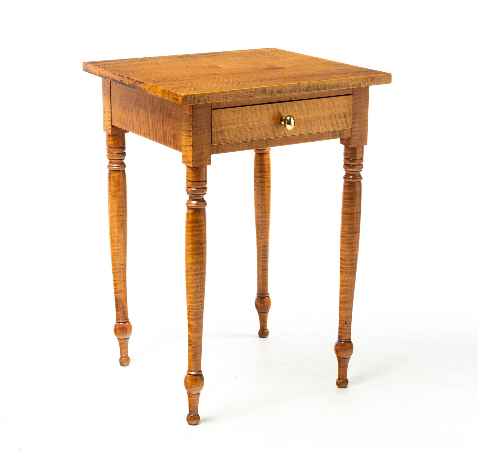 SHERATON STYLE TIGER MAPLE ONE-DRAWER STAND.: SHERATON STYLE TIGER MAPLE ONE-DRAWER STAND. American, 20th Century. Pine secondary. One board top, dovetailed drawer with brass knob and turned legs. 29.5"h. 20.5"w. 20"d. Provenance: From the Lifeti