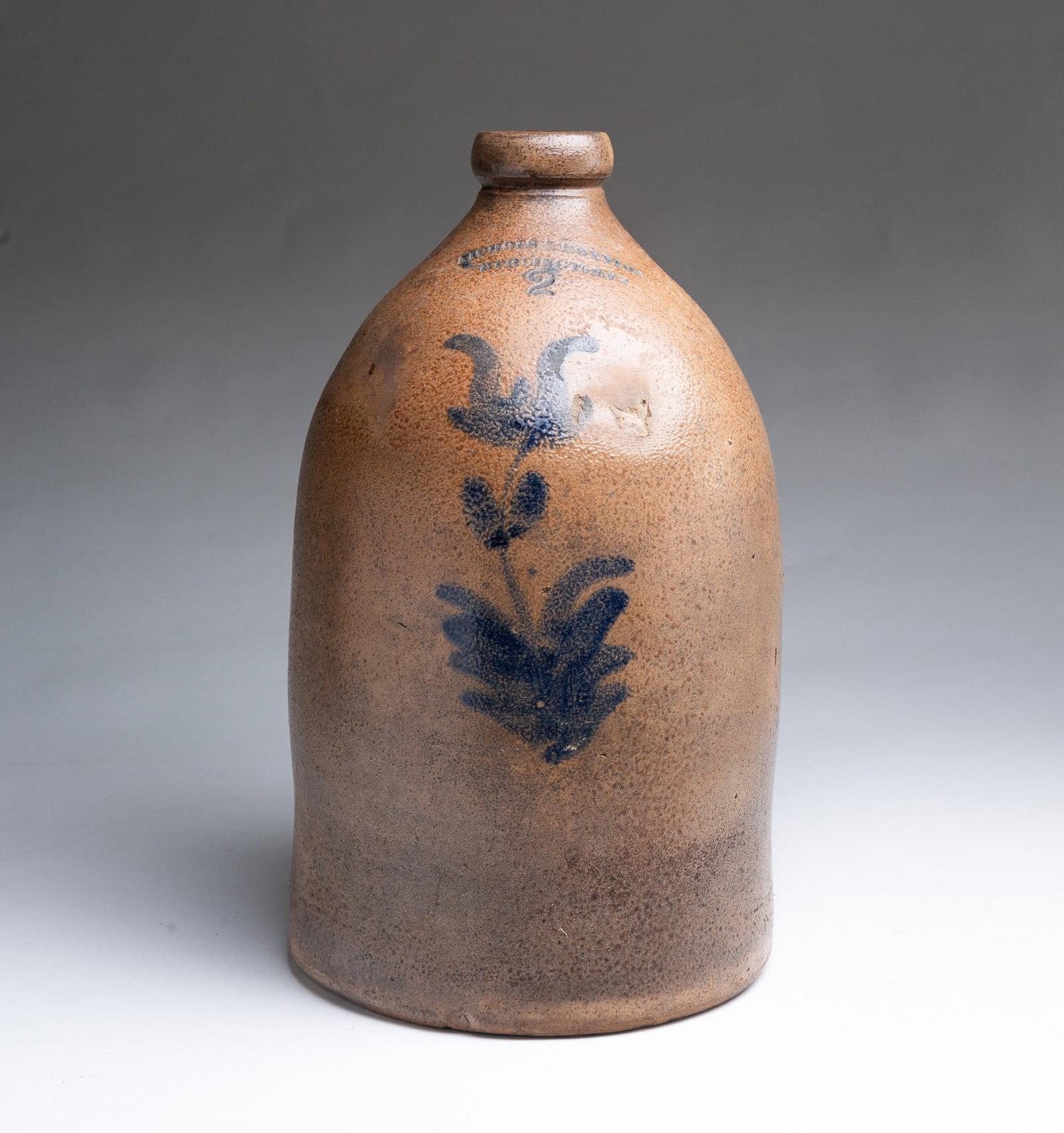 VERMONT NICHOLS AND BOYNTON TWO-GALLON STONEWARE JUG.: VERMONT NICHOLS AND BOYNTON TWO-GALLON STONEWARE JUG. American, 19th Century. Applied handle, impressed "NICHOLS AND BOYNTON, BURLINGTON, VE" and cobalt freehand tulip. 14.5"h. Provenance: The Lifetim
