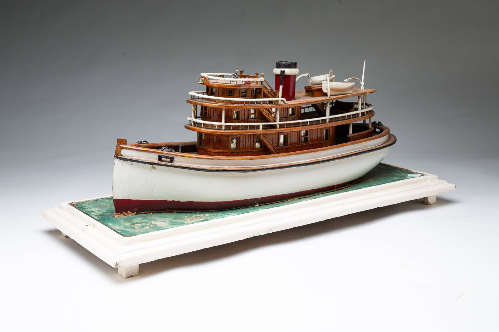 SCALE MODEL OF A TUGBOAT ON BASE.: SCALE MODEL OF A TUGBOAT ON BASE. American, 19th Century. Scale model of a small cruising or tug boat featuring detailed wood construction and painted accents. The vessel is mounted on a rectangular