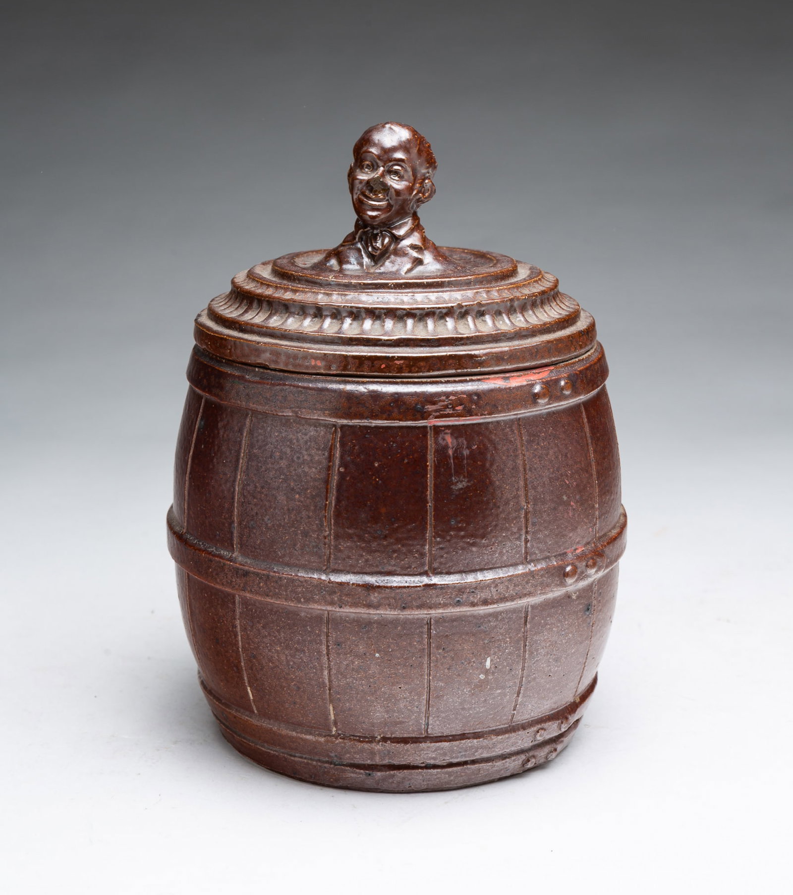 SEWER TILE BARREL-FORM TOBACCO JAR WITH BUST OF WILL ROGERS ON LID.: SEWER TILE BARREL-FORM TOBACCO JAR WITH BUST OF WILL ROGERS ON LID. American, 20th Century. Barrel-form body with incised and applied details, the banded and decorated lid having a molded bust of the