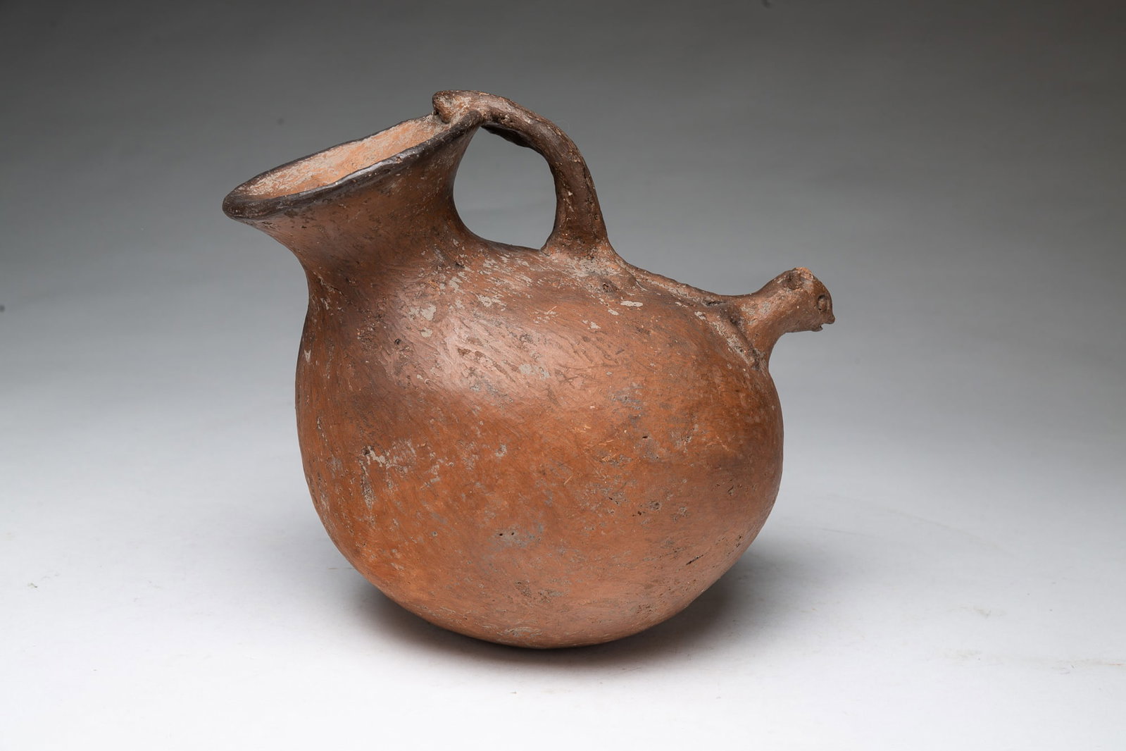 TERRACOTTA CLAY POT WITH SQUIRREL HANDLE.: TERRACOTTA CLAY POT WITH SQUIRREL HANDLE. American, Late 19th or early 20th Century. Terracotta pot with a unique squirrel-shaped handle, bulbous body with a squirrel head spout. 9"h. Provenance: From