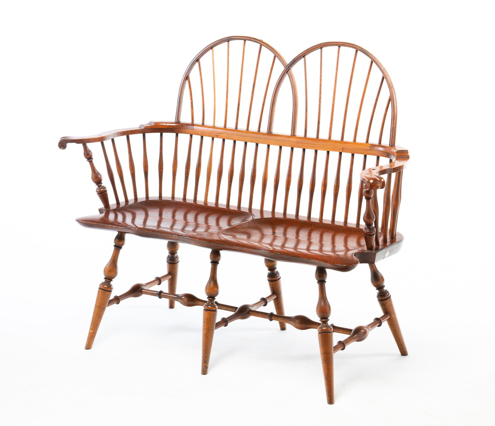 WINDSOR SACK BACK SETTEE.: WINDSOR SACK BACK SETTEE. American, 20th Century. Mixed woods. Double hoop crest, spindle back, knuckle arms, boldly turned stiles, legs, and stretchers with double saddle seat. 18" seat. 40"h. 49"w.
