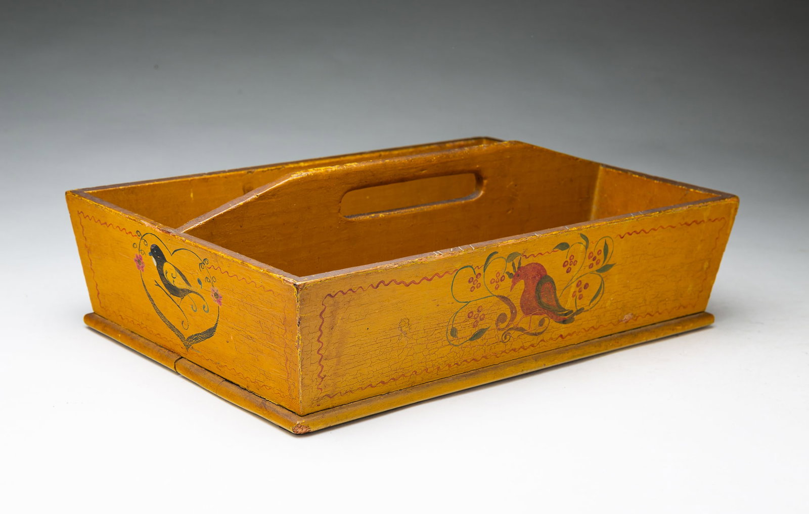 FOLKSY CUTLERY TRAY IN ORIGINAL PAINTED DECORATION, INCLUDING BIRDS AND BERRIES.: FOLKSY CUTLERY TRAY IN ORIGINAL PAINTED DECORATION, INCLUDING BIRDS AND BERRIES. American, 19th Century. Pine. Rectangular form with canted sides and central divider with a cut out handle, the sides