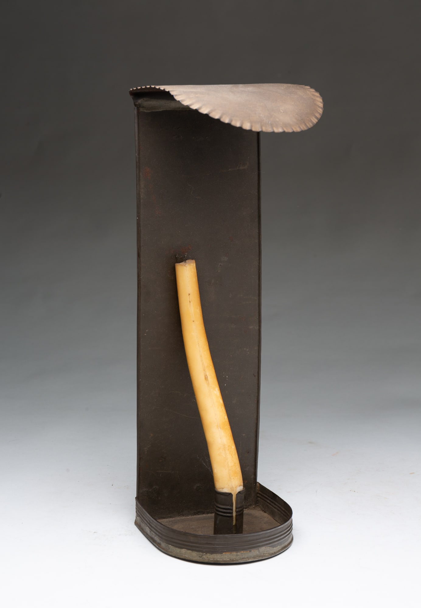 ROUNDED TOP CANDLE SCONCE.: ROUNDED TOP CANDLE SCONCE. American, 19th Century. Tinned sheet metal. Rounded top with crimped edge, straight back and rounded pan with folded edges, and with a single candle socket. 14.25"h. 4.5"w.