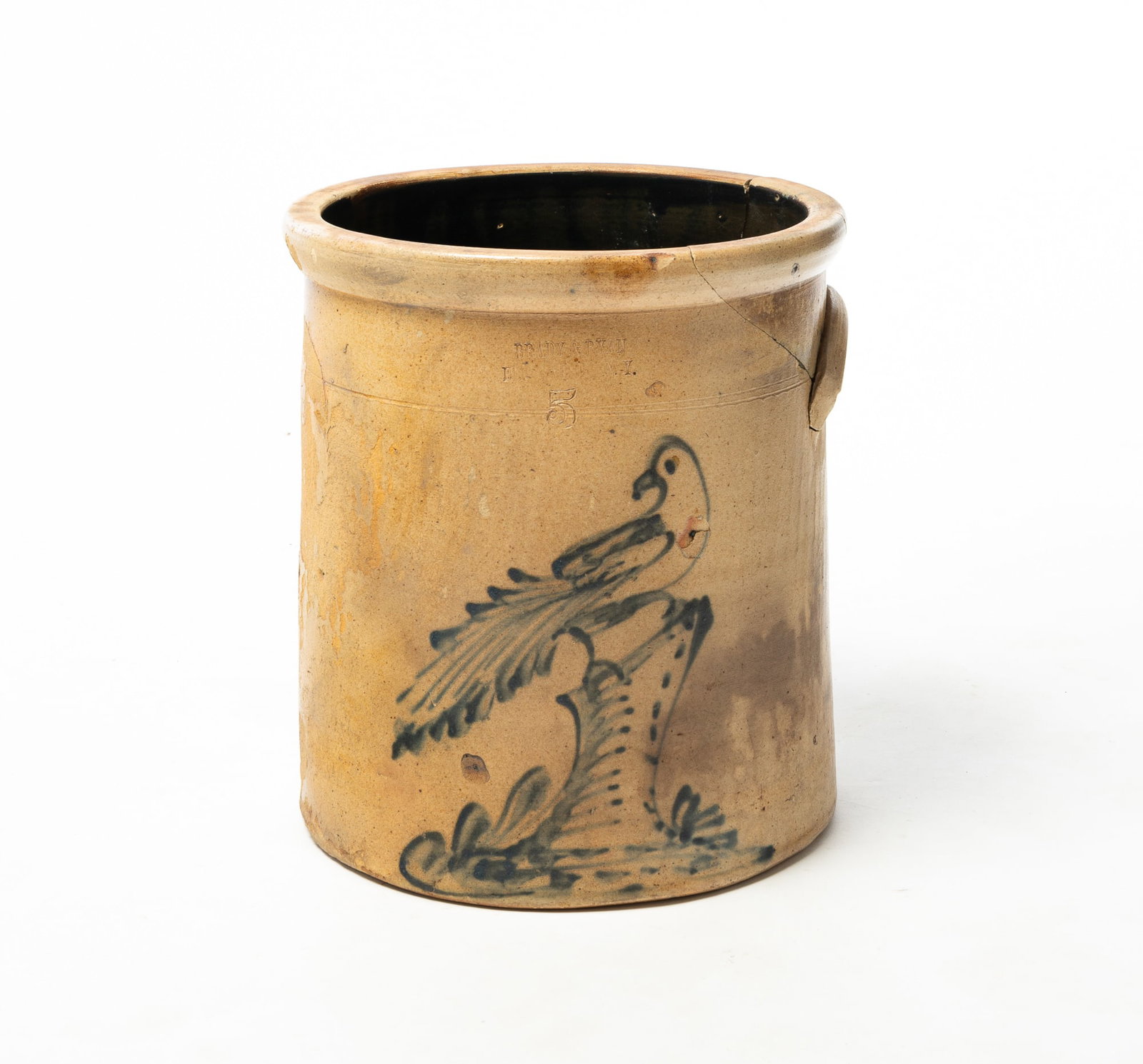 BRADY & RYAN (ELLENVILLE, NEW YORK) COBALT-DECORATED STONEWARE FIVE-GALLON CROCK WITH BIRD.: BRADY & RYAN (ELLENVILLE, NEW YORK) COBALT-DECORATED STONEWARE FIVE-GALLON CROCK WITH BIRD. American, 19th Century. Impressed mark, cobalt bird resting on stump, and singular handle. 13.5"h. 12"d.