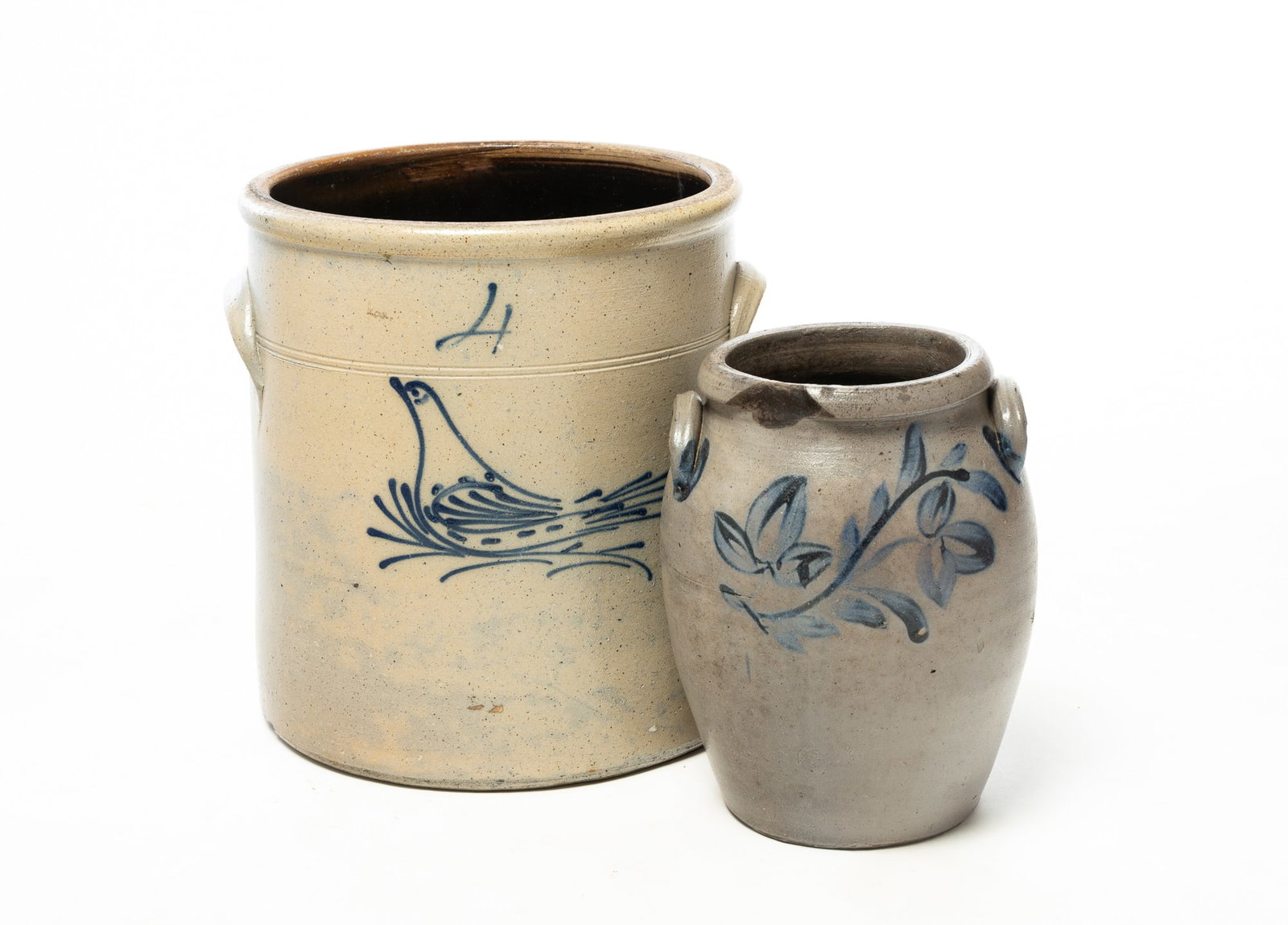 TWO COBALT DECORATED STONEWARE VESSELS.: TWO COBALT DECORATED STONEWARE VESSELS. American, 19th Century. A four-gallon crock of cylindrical form with applied lug handles, rolled rim, and fine slip-cobalt decoration of a bird, 12"h. Together 