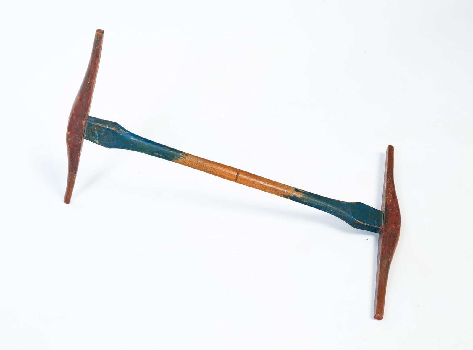 CARVED WOODEN NIDDY NODDY WITH ORIGINAL PAINT.: CARVED WOODEN NIDDY NODDY WITH ORIGINAL PAINT. American, 19th Century. Carved center standard with blue paint at either end, the ends with red paint. 18"l. 12"w. 12"d.