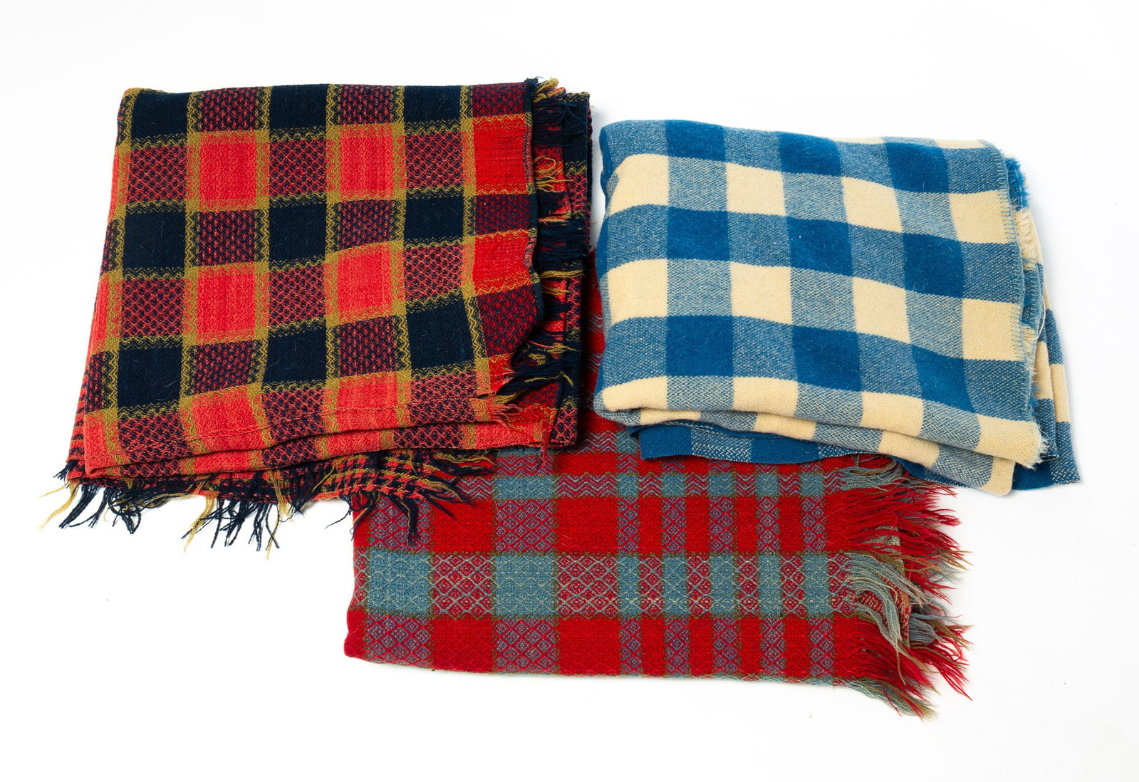 THREE PLAID WOOL HOMESPUN BLANKETS.: THREE PLAID WOOL HOMESPUN BLANKETS. American, 19th Century. Blue and cream plaid, 60"l. 70"w. Red, blue, and green plaid two-piece with handstitched center seam, 72"l. 80"w. And a blue and red