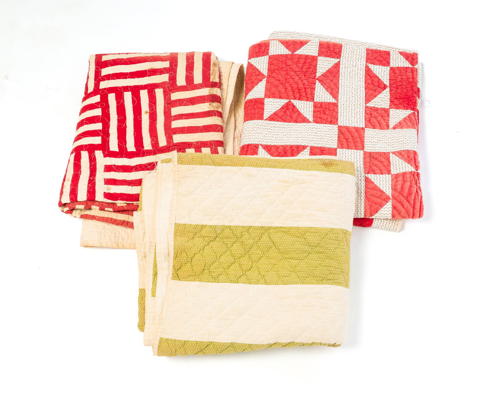 THREE PIECEWORK QUILTS.: THREE PIECEWORK QUILTS. American, 20th Century, Cotton. One red with white patterned background in squares and triangles, 46"w. 72"l., squares in red and white stripes, 56"w. 74"l., and white and