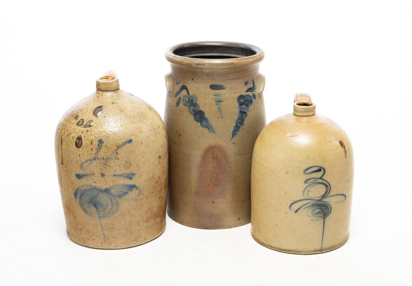 THREE STONEWARE ITEMS WITH FREEHAND COBALT DECORATION.: THREE STONEWARE ITEMS WITH FREEHAND COBALT DECORATION. American, 19th Century. A four-gallon jug with applied handle, "4", and bee stinger decoration. 16.5 h., a three-gallon jug with applied handle,