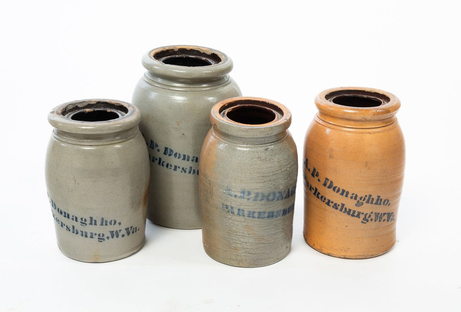 FOUR PARKERSBURG, WEST VIRGINIA, DONAGHHO STONEWARE CANNING JARS WITH STENCILED LABELS.: FOUR PARKERSBURG, WEST VIRGINIA, DONAGHHO STONEWARE CANNING JARS WITH STENCILED LABELS. American, 19th Century. All with well-formed lips, tooled bands, and stenciled "A.P. Donaghho, Parkersburg, W.Va