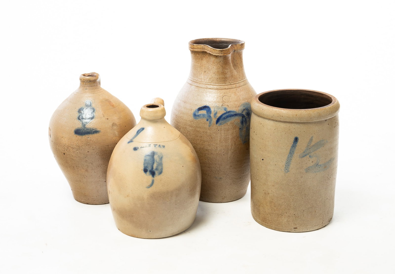 FOUR STONEWARE ITEMS WITH FREEHAND COBALT DECORATION.: FOUR STONEWARE ITEMS WITH FREEHAND COBALT DECORATION. American, 19th Century. Two ovoid jugs with applied handles: one is impressed "PENN YAN" with cobalt flower, 10.5"h., and the second with cobalt