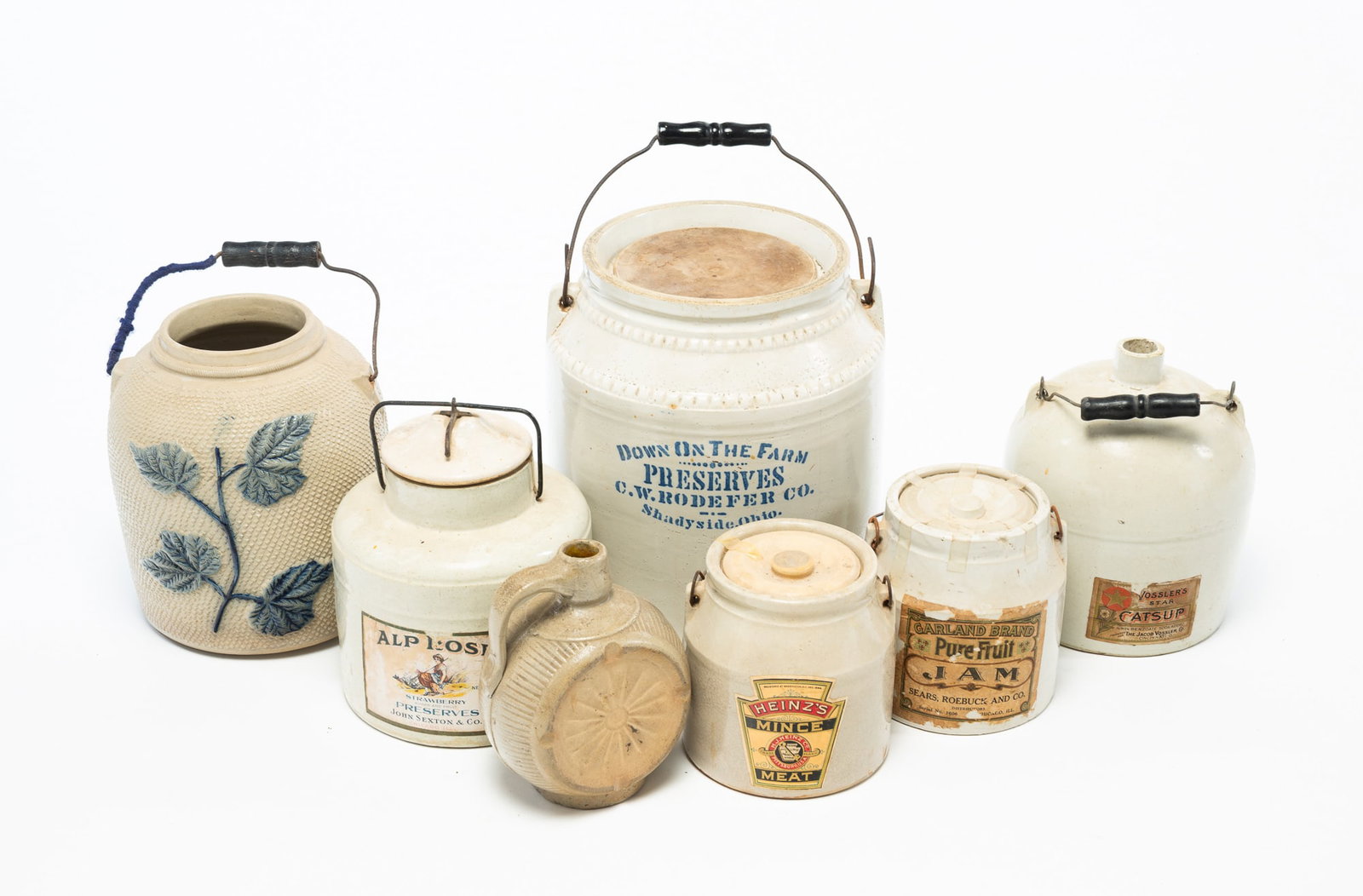 SIX STONEWARE STORAGE JARS AND JUGS, INCL. HEINZ.: SIX STONEWARE STORAGE JARS AND JUGS, INCL. HEINZ. American, 19th and 20th Centuries. Comprising five jars and two jugs. Four with paper labels for "HEINZ'S MINCE MEAT", "GARLAND BRAND PURE FRUIT JAM",