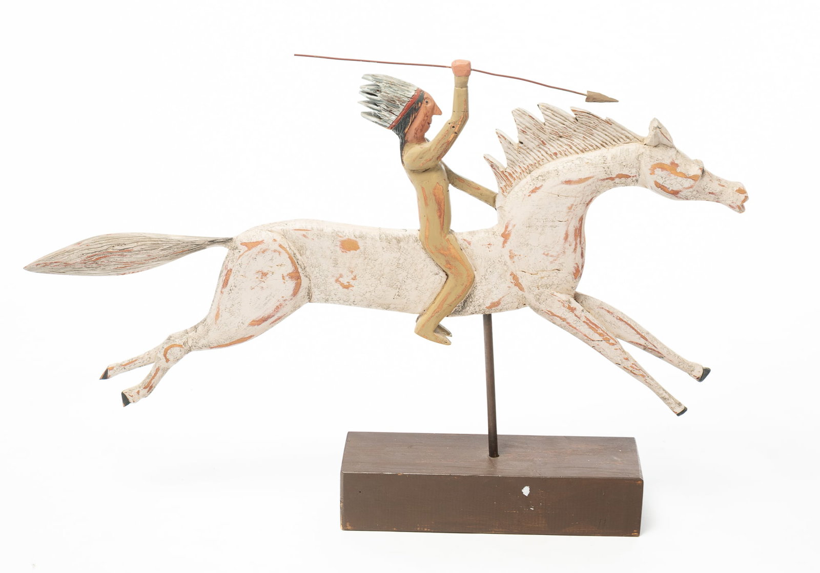 FOLKSY WOOD CARVING OF A NATIVE AMERICAN ON HORSEBACK .: FOLKSY WOOD CARVING OF A NATIVE AMERICAN ON HORSEBACK . American, 20th Century. Hand-carved and painted wooden depiction of a Native American figure riding a galloping horse, featuring vivid details