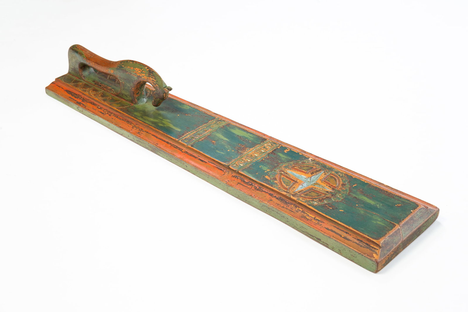 FOLK ART CARVED AND PAINTED MANGLE BOARD.: FOLK ART CARVED AND PAINTED MANGLE BOARD. European, 19th Century. Maple. Horse handle, board with routed edge, chip carved bands, pinwheel with star and green, salmon, and blue paint. 4"h. 27"l.