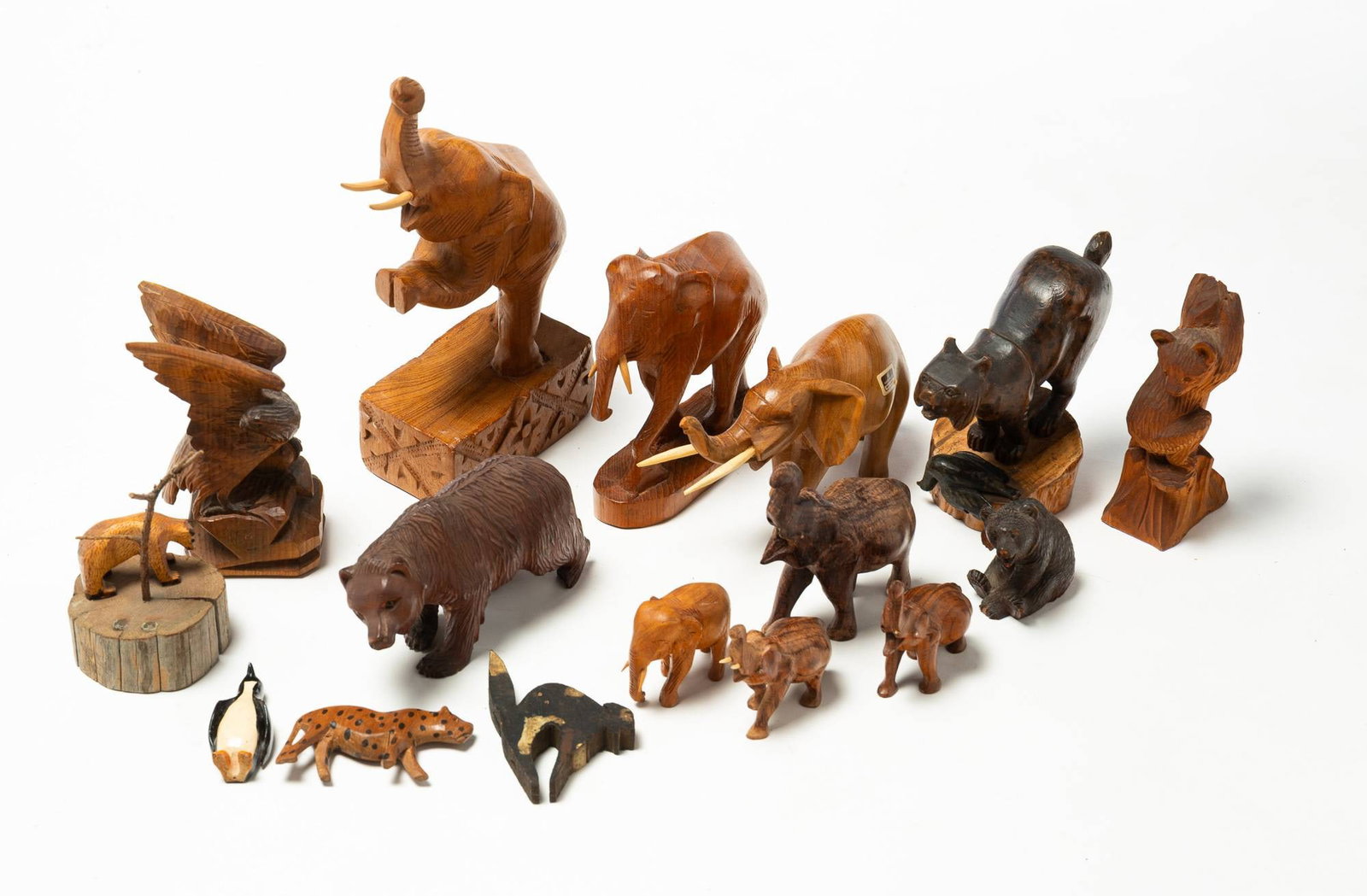 LARGE GROUP OF FOLKSY WOODEN ANIMAL CARVINGS.: LARGE GROUP OF FOLKSY WOODEN ANIMAL CARVINGS. 20th Century. Hand-crafted wooden animal carvings, including elephants, bears, penguins, and a variety of others. Includes a piece marked "Hand Made Teakw