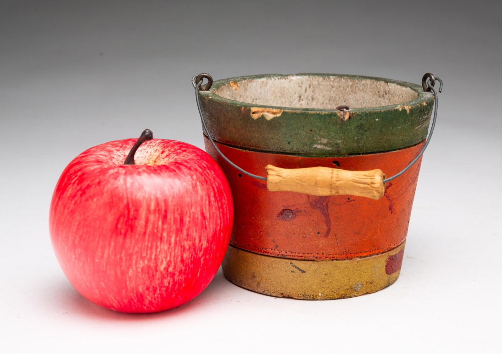 UNUSUAL MINIATURE CARVED AND PAINTED ONE-PIECE WOODEN BERRY BUCKET WITH ORIGINAL PAINT.: UNUSUAL MINIATURE CARVED AND PAINTED ONE-PIECE WOODEN BERRY BUCKET WITH ORIGINAL PAINT. American, 19th Century. Carved from a single piece of wood, having a bail handle and the body painted in green,