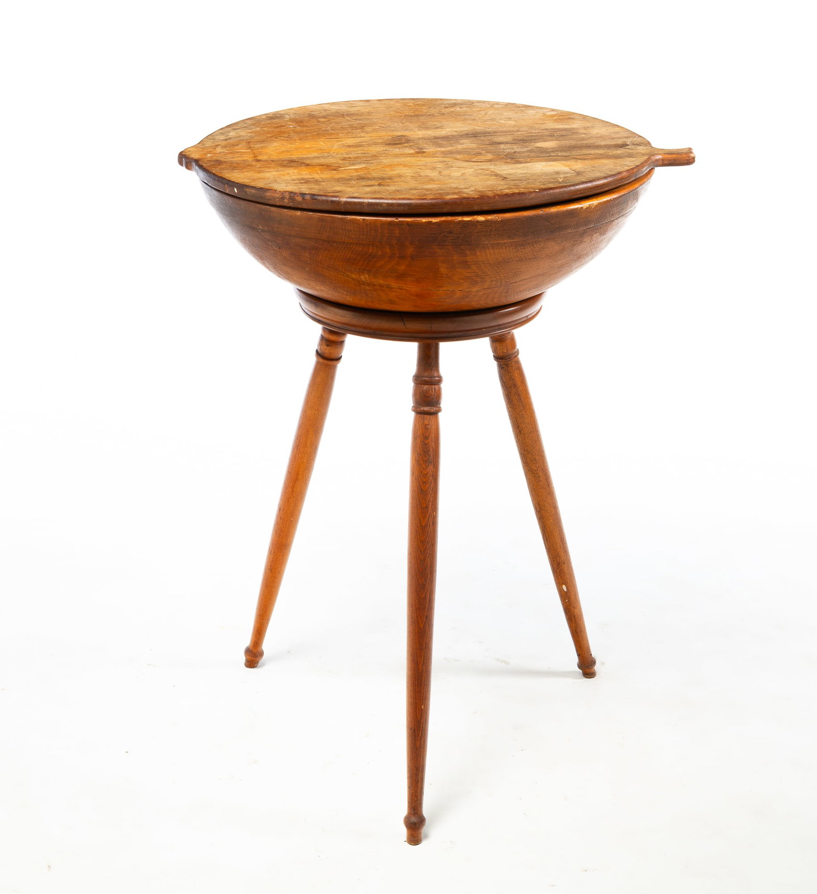 TURNED AND LIDDED BOWL ON LEGS.: TURNED AND LIDDED BOWL ON LEGS. American, 20th Century. Mixed woods. Turned bowl out of round, lid with tab handles, and atop a base with three turned and splayed legs. 28"d. 22"w. Provenance: The