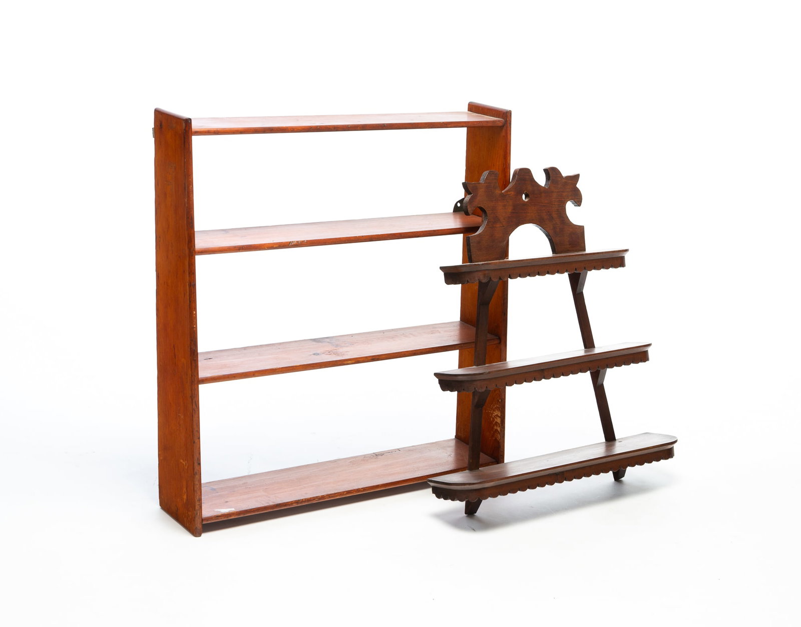 TWO HANGING SHELVES.: TWO HANGING SHELVES. American, 19th Century. One is poplar, stylized tulip crest, open back, three graduated shelves with rounded corners and scalloped aprons. 27.5"h. 23.75"w. 5.5"d. and the second