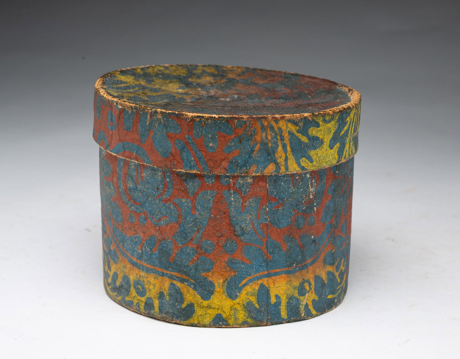 DIMINUTIVE WALLPAPER BOX.: DIMINUTIVE WALLPAPER BOX. American, 19th Century. Circular box with newspaper lining, sewn seams, and vibrant hand-blocked wallpaper covering. Personalized note to bottom. 4.25"h. 5.25"d. Provenance: