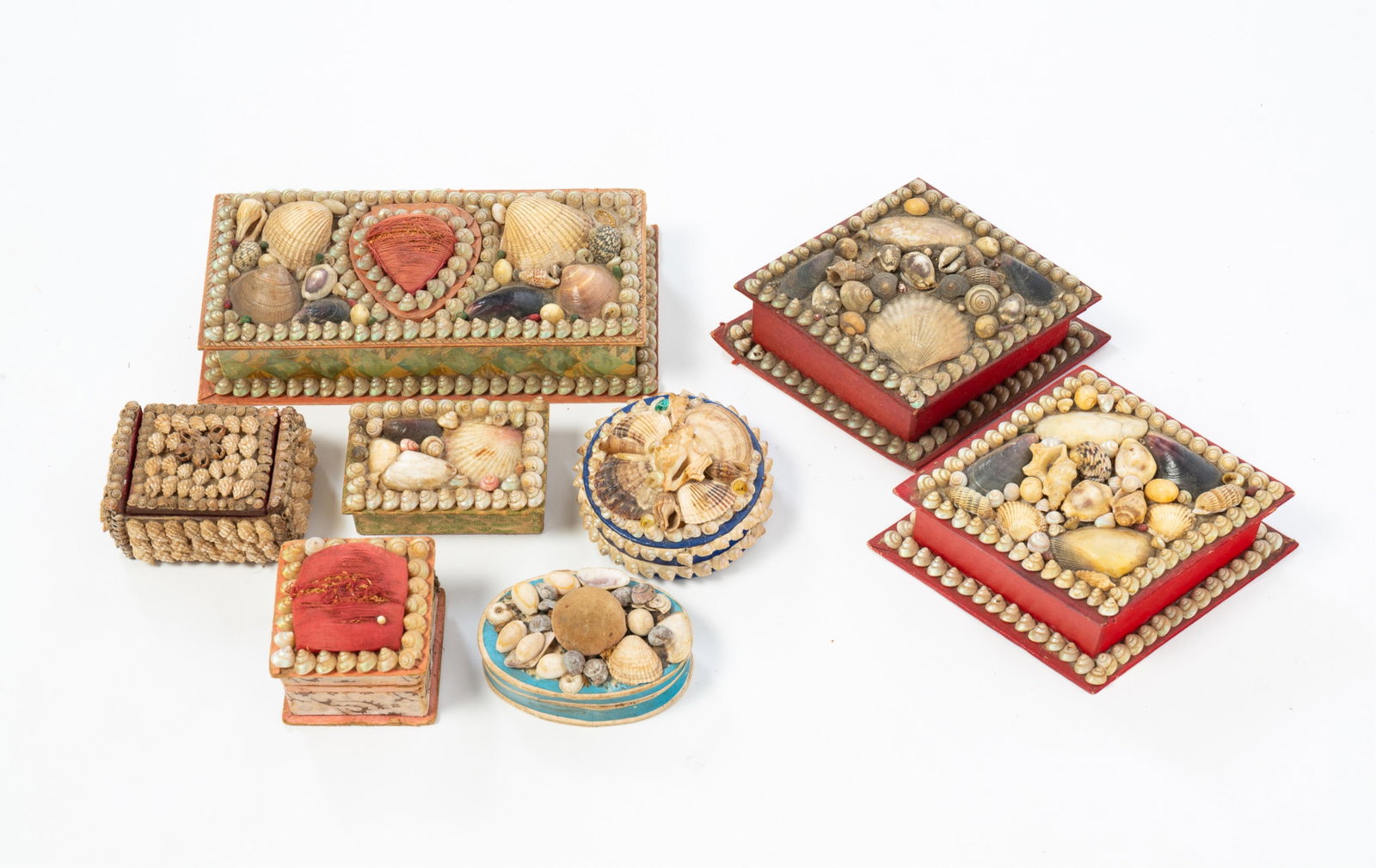 EIGHT SHELL ART TRINKET BOXES.: EIGHT SHELL ART TRINKET BOXES. 20th Century. An oval, a cube, and a rectangle with pincushions on lids, two diamond shapes, two rectangular, and one round. Largest is 2.25"h. 8"w. 3.75"d. Provenance: