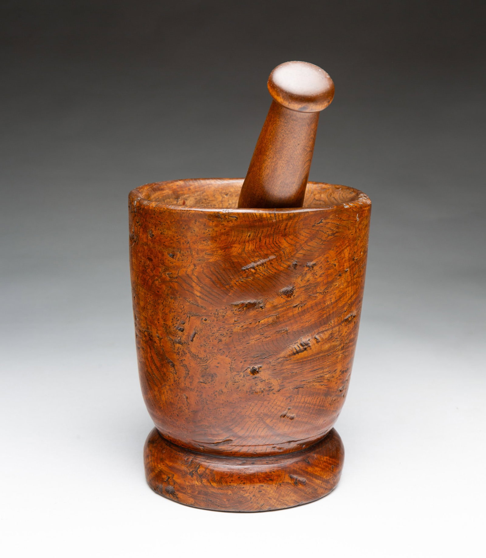 BURL MORTAR AND PESTLE.: BURL MORTAR AND PESTLE. American, 19th Century. Mortar with cylindrical form, slight foot, and tall sides, 7.25"h. Pestle in typical form with turned handle and knob finial, 8"h. Provenance: From the
