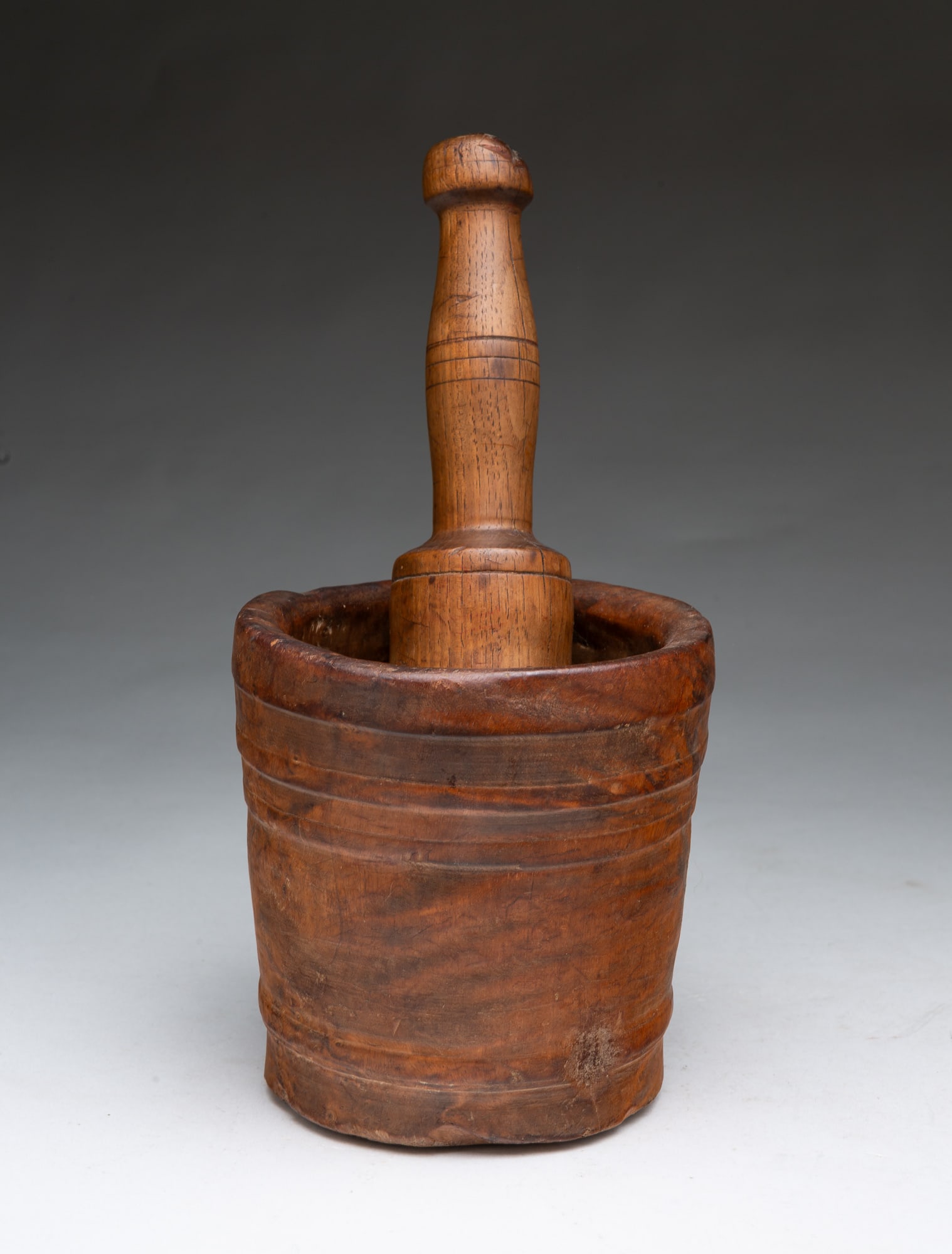 CARVED BURL MORTAR AND TURNED WOOD PESTLE.: CARVED BURL MORTAR AND TURNED WOOD PESTLE. American, 19th Century. Slightly tapered mortar with incised bands, together with a later hardwood pestle in typical form with incised bands. Mortar, 5.5"h.