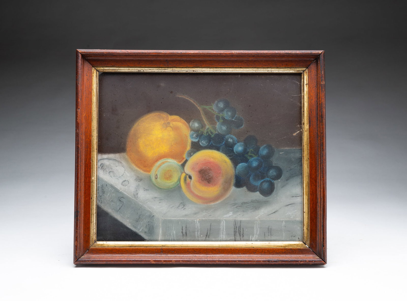 FRAMED PASTEL STILL LIFE.: FRAMED PASTEL STILL LIFE. American, 19th Century. On heavy paper. A peach, an orange, a bunch of grapes, and a fig on a marble top table. In a walnut shadow box frame, 12"h. 14"w. Provenance: The