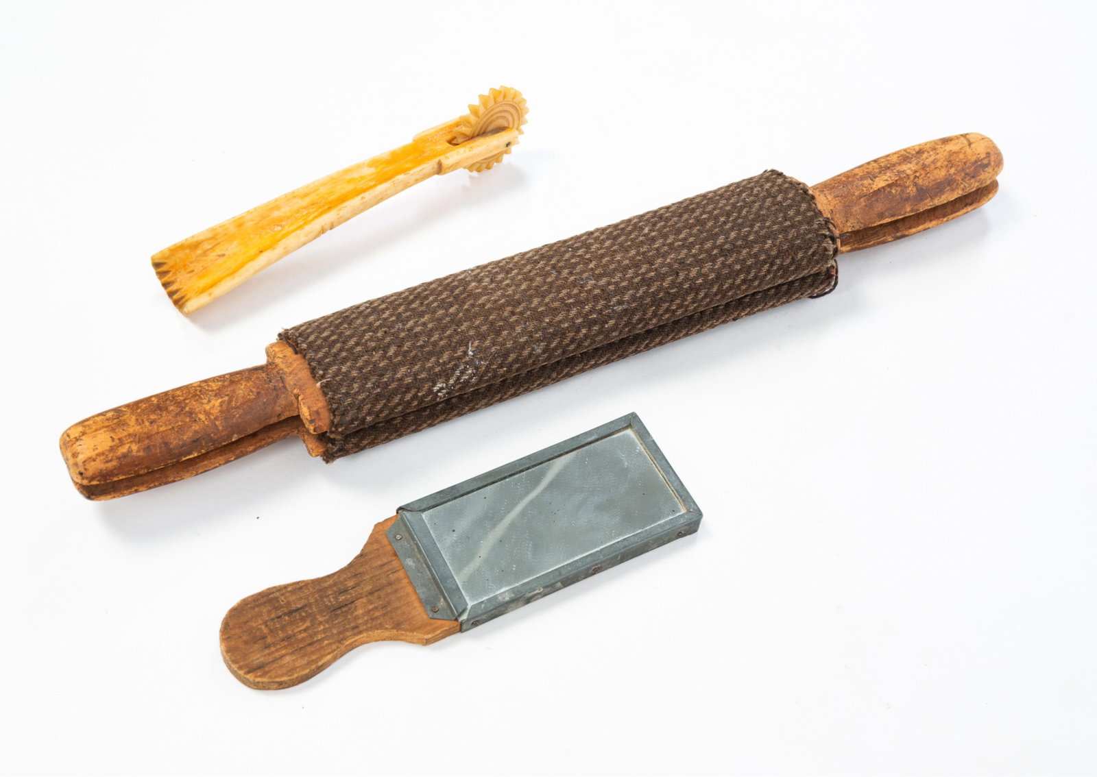A SCRIMSHAW BONE PIE CRIMPER, A HAND MIRROR, AND A HAND PRESS. (1 of 5)