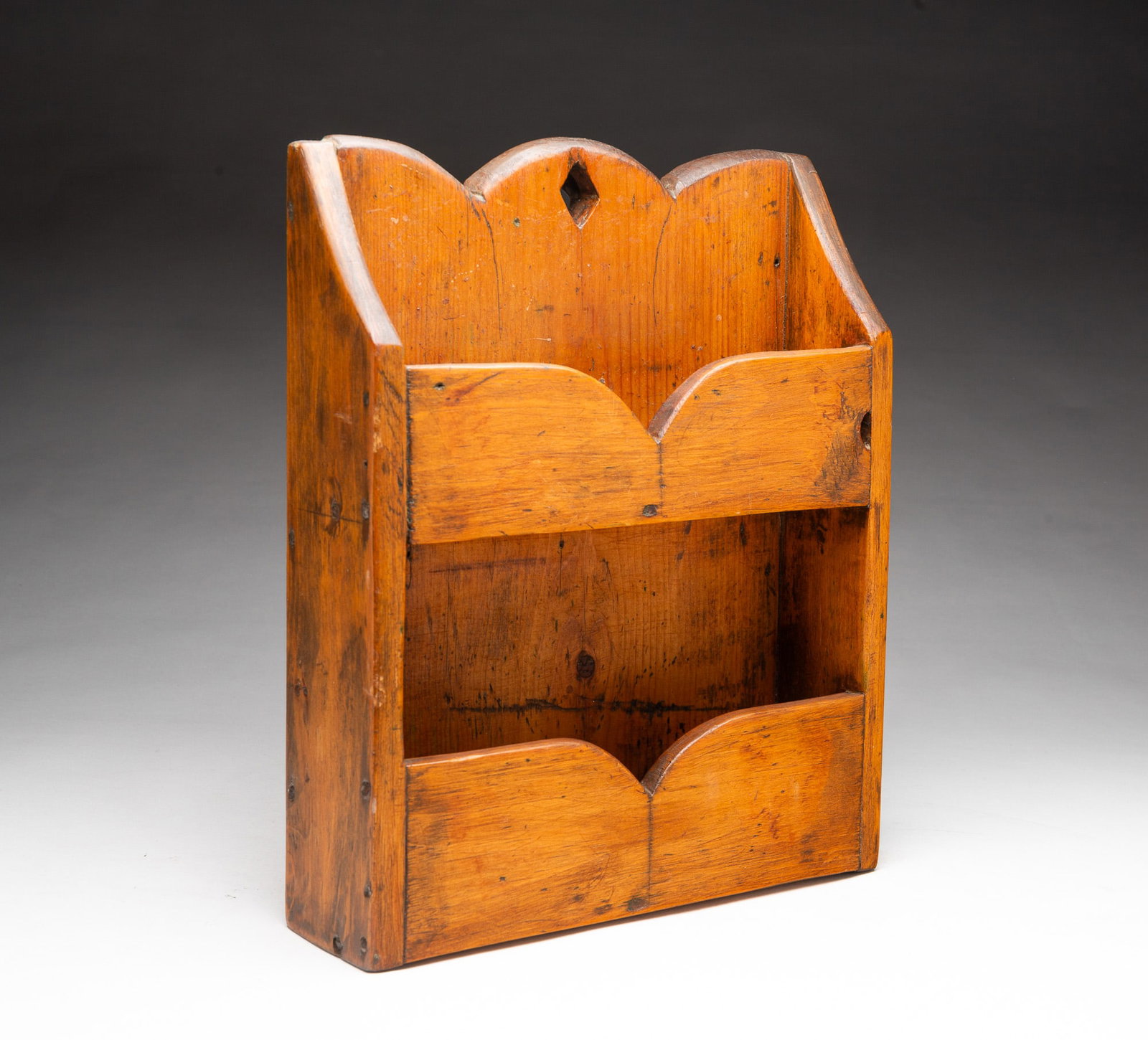 PINE DOUBLE WALL POCKET.: PINE DOUBLE WALL POCKET. American, 19th Century. Simple construction with rosehead nails. Shaped back and fronts with a diamond-shaped hanging hole. 3"h. 11"w. 3"d.