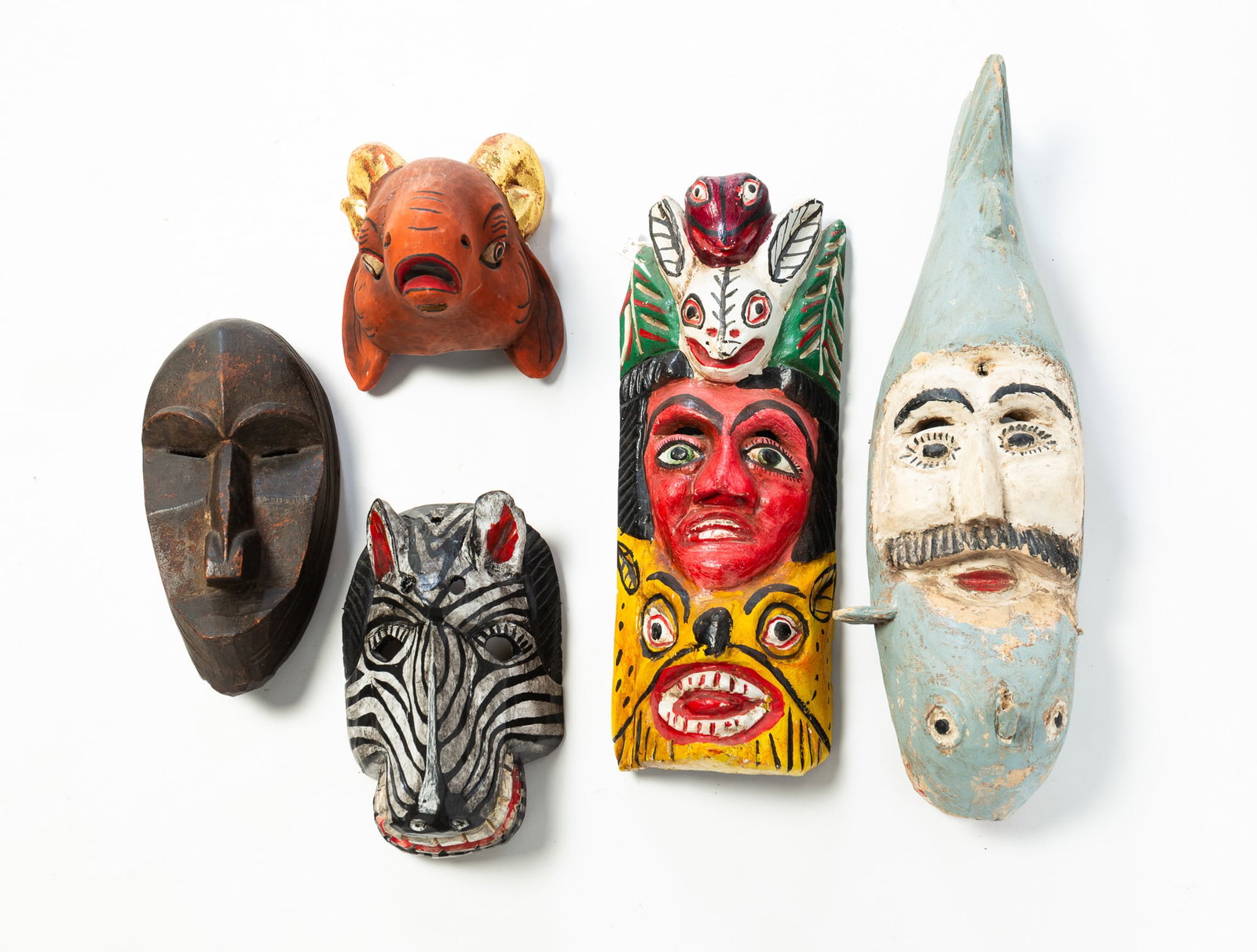 FIVE CARVED WOOD MASKS WITH PAINTED DECORATION. (1 of 6)