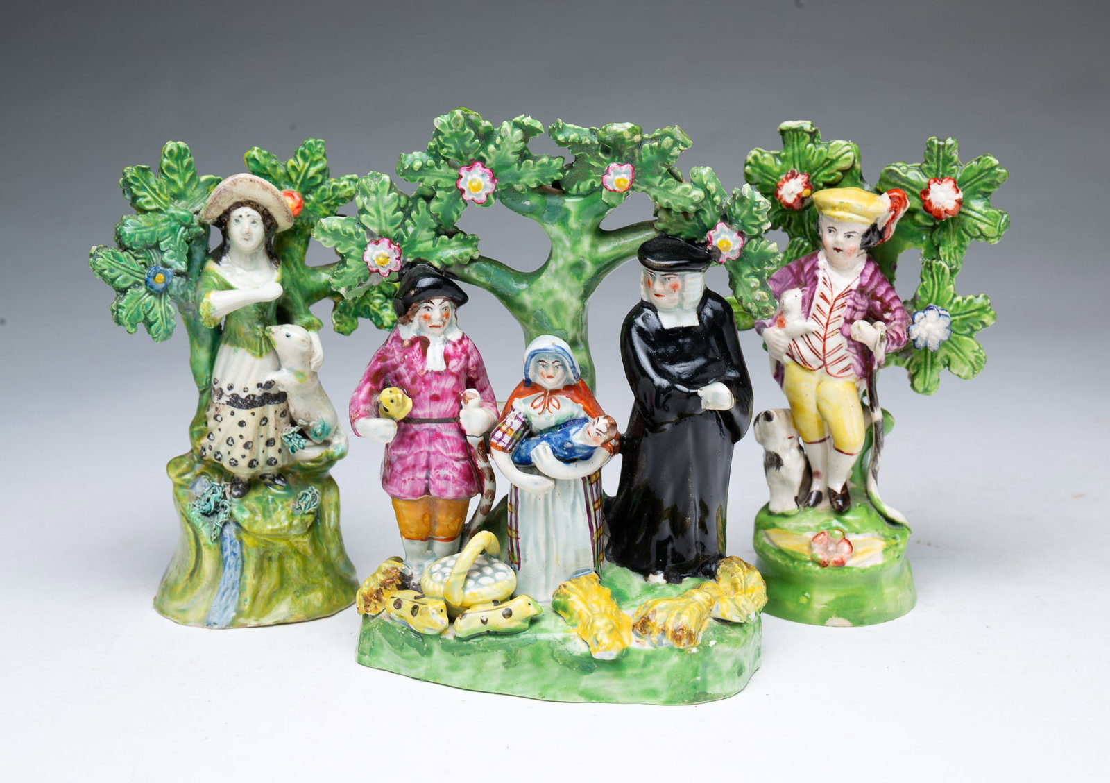 THREE STAFFORDSHIRE BOCAGE FIGURINES, ONE SIGNED WALTON.: THREE STAFFORDSHIRE BOCAGE FIGURINES, ONE SIGNED WALTON. England, 19th Century. Includes "Tithe Pig" grouping depicting a farmer and his wife presenting their tithes to the preacher; a boy with a